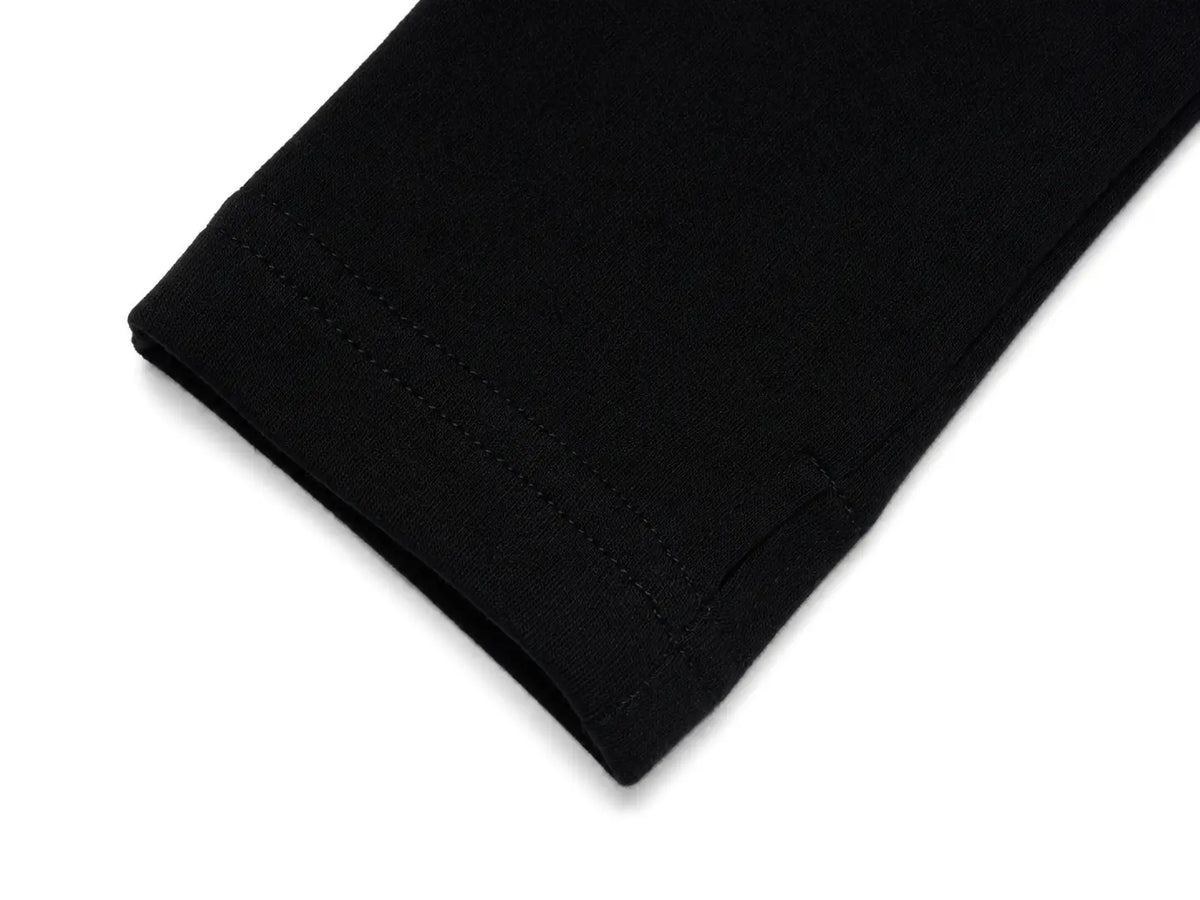 Close-up of a black fabric cuff with neat double stitching, shown on a plain white background. TCH Rhinestone Fleur-de-Lis Fitted Long Sleeve Top