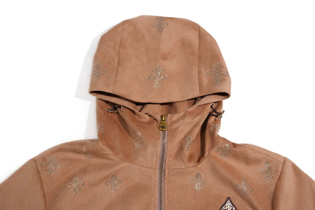 A close-up of a tan hooded jacket with a full front zipper and a repeating metallic cross motif across the fabric, shown against a plain white background. TCH Rhinestone Fleur-de-Lis Hooded Jacket