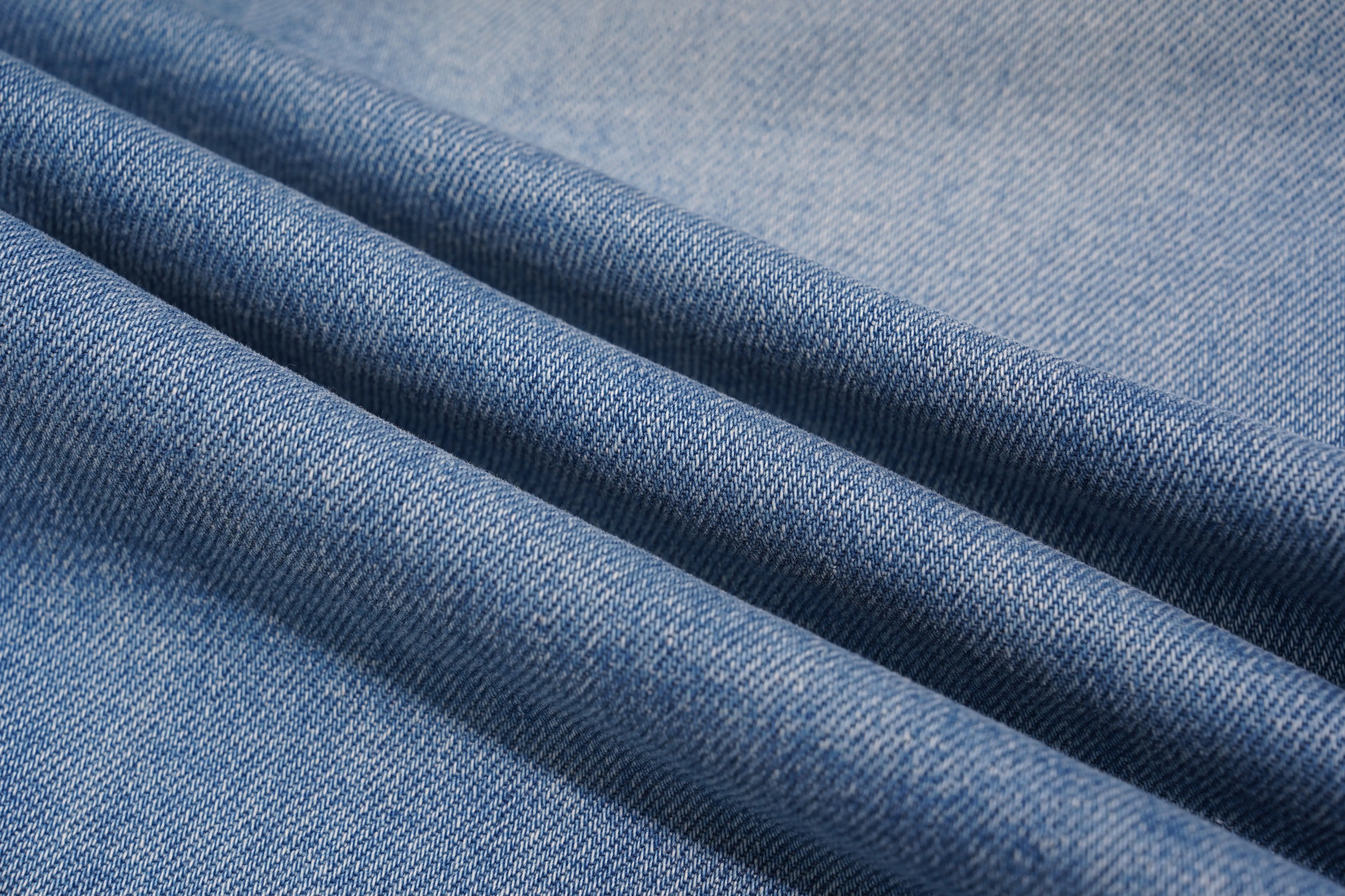 Close-up of blue denim fabric with visible texture, TCH Rhinestone Floral Logo Wide-Leg Denim Shorts