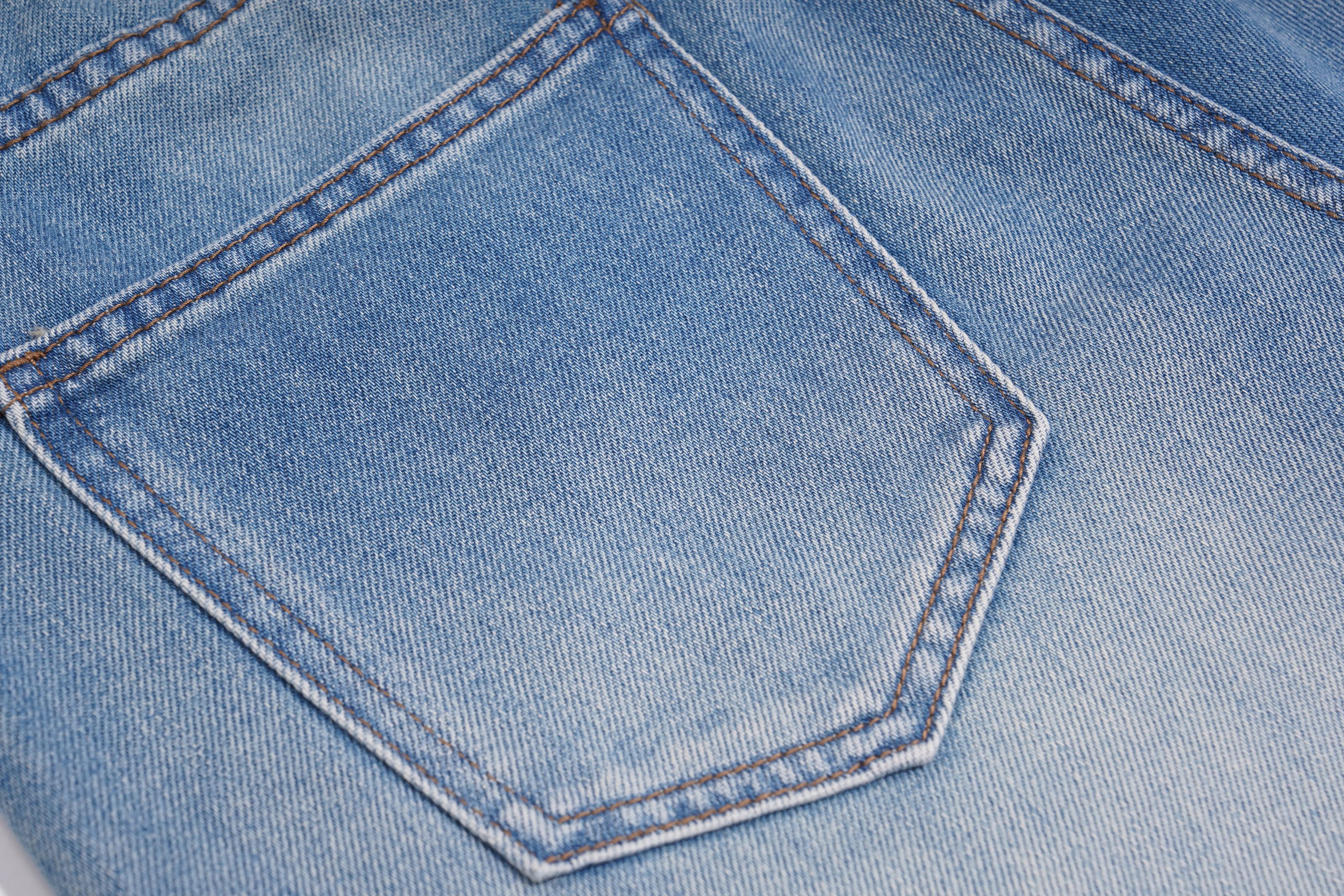 Close-up of a blue denim pocket with stitching details, TCH Rhinestone Floral Logo Wide-Leg Denim Shorts