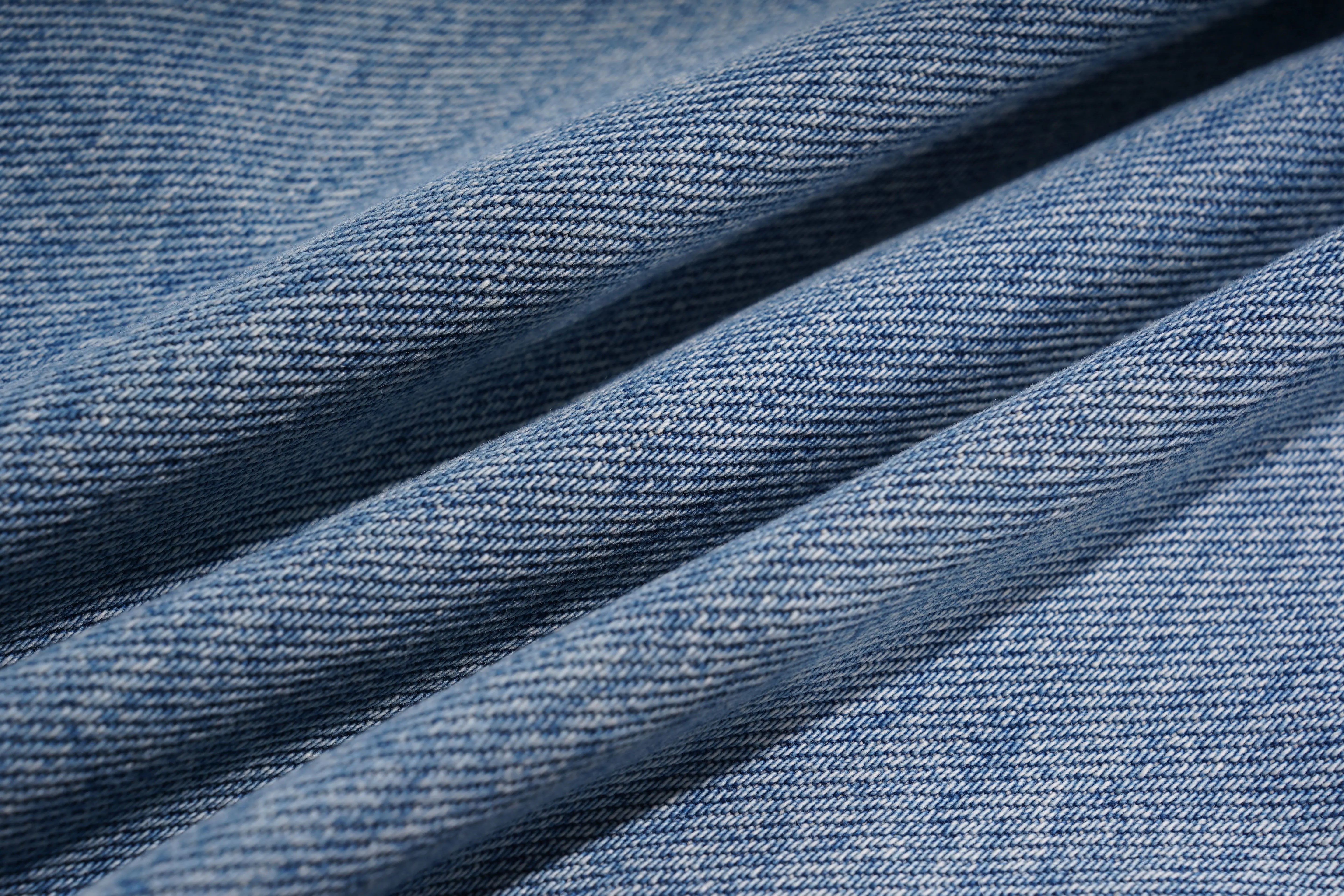 Close-up of blue denim fabric with visible texture, TCH Rhinestone Floral Wide-Leg Blue Jeans