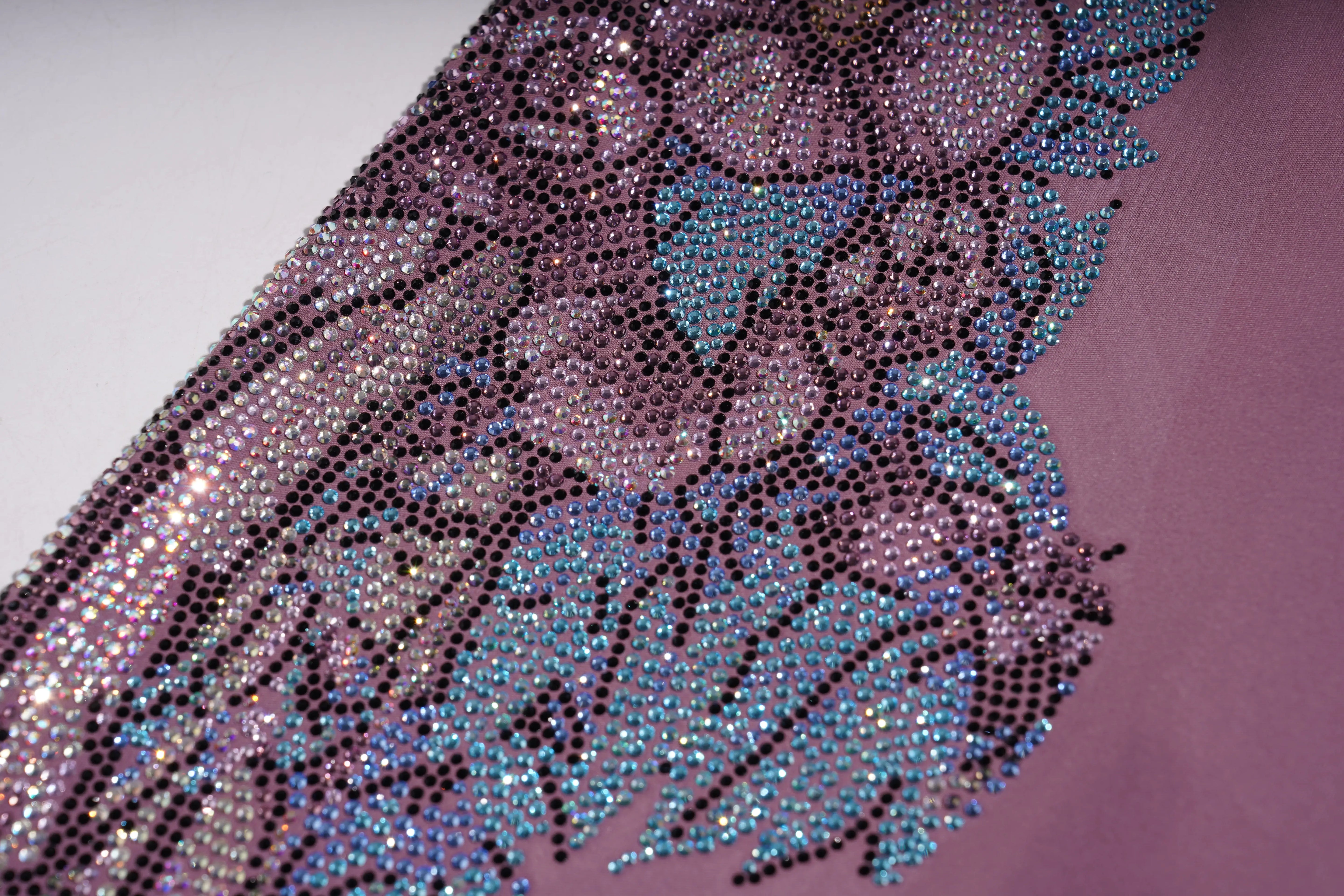 Close-up of a decorative fabric with rhinestone embellishments on a pink background, TCH Rhinestone Floral Wing High-Waist Leggings
