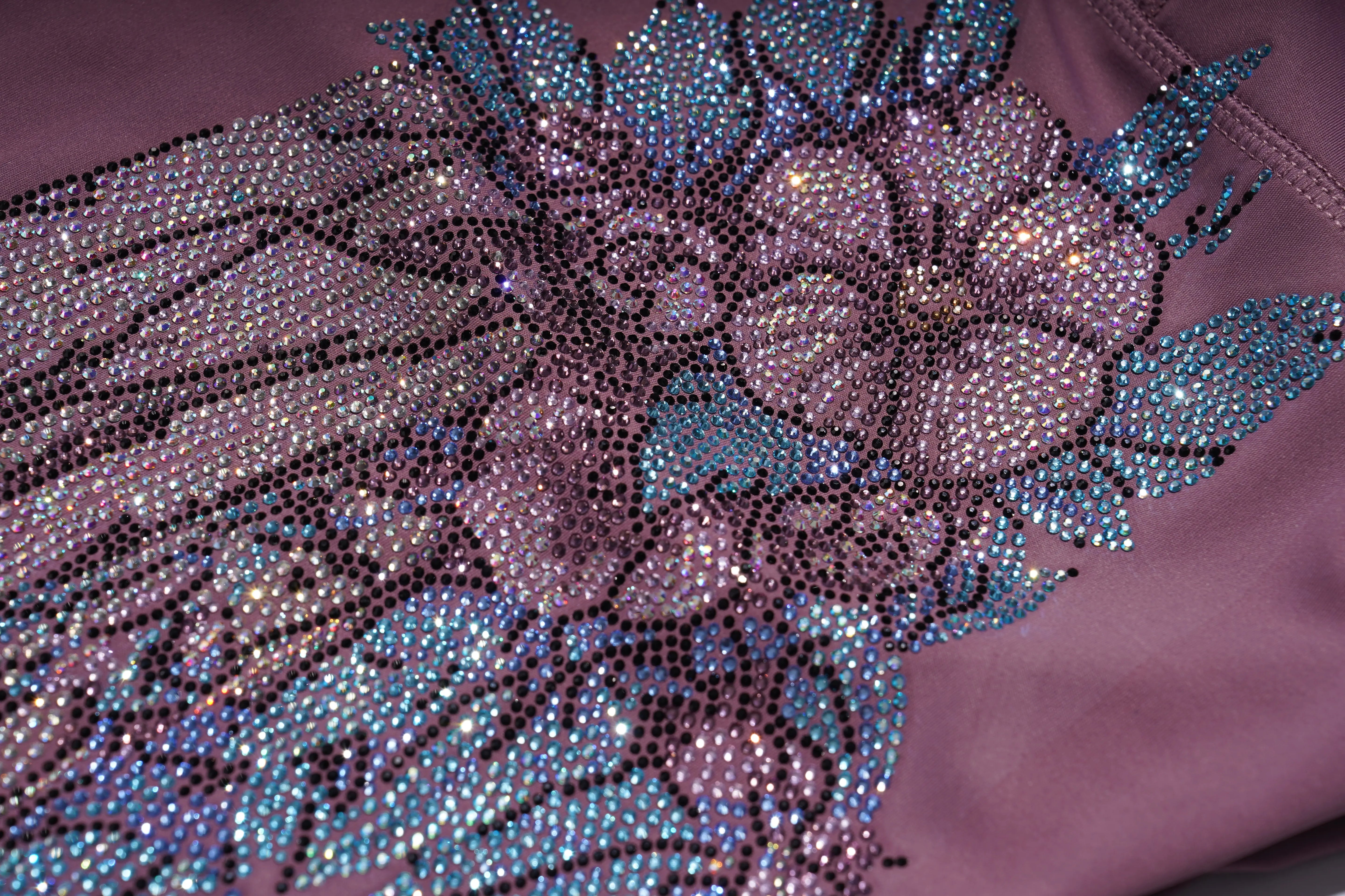 Close-up of a purple fabric with intricate beadwork and floral patterns. TCH Rhinestone Floral Wing High-Waist Leggings