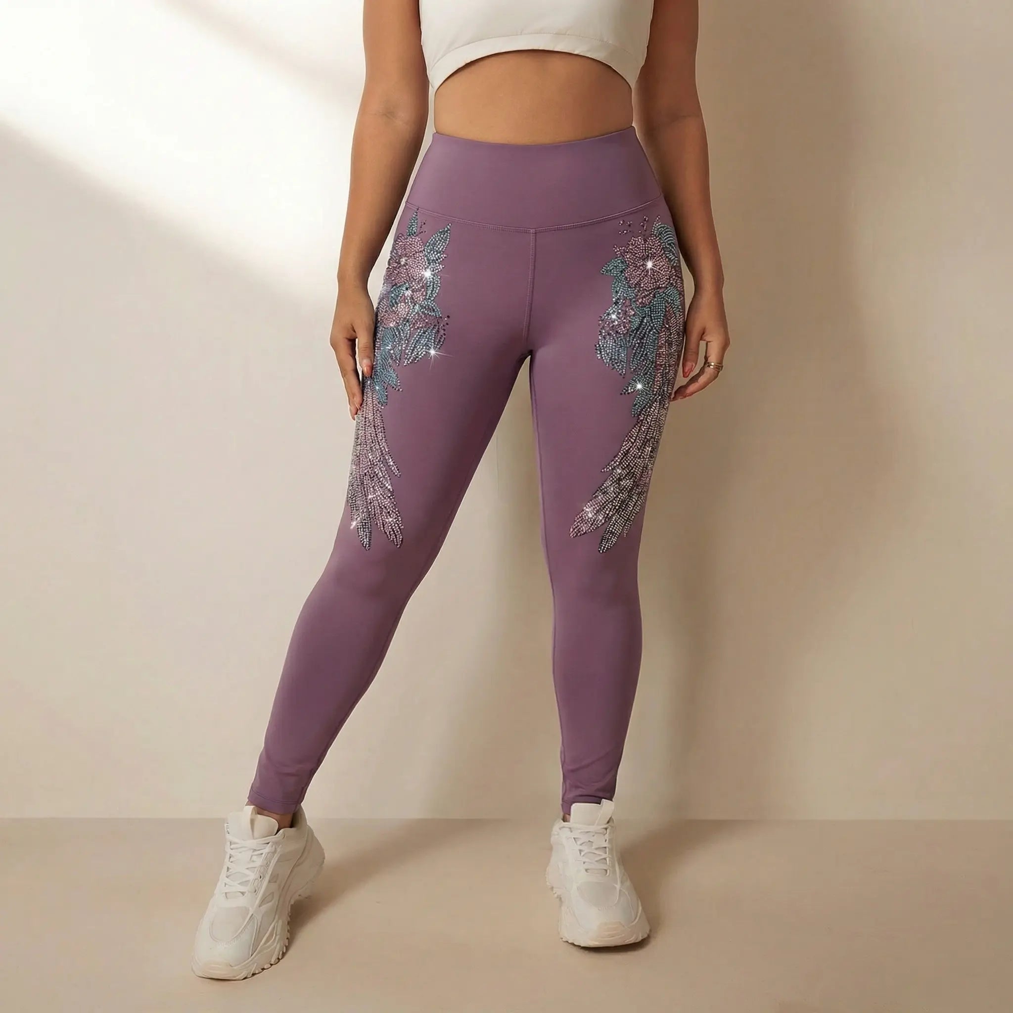 Person wearing purple leggings with floral embellishments on a beige background. TCH Rhinestone Floral Wing High-Waist Leggings