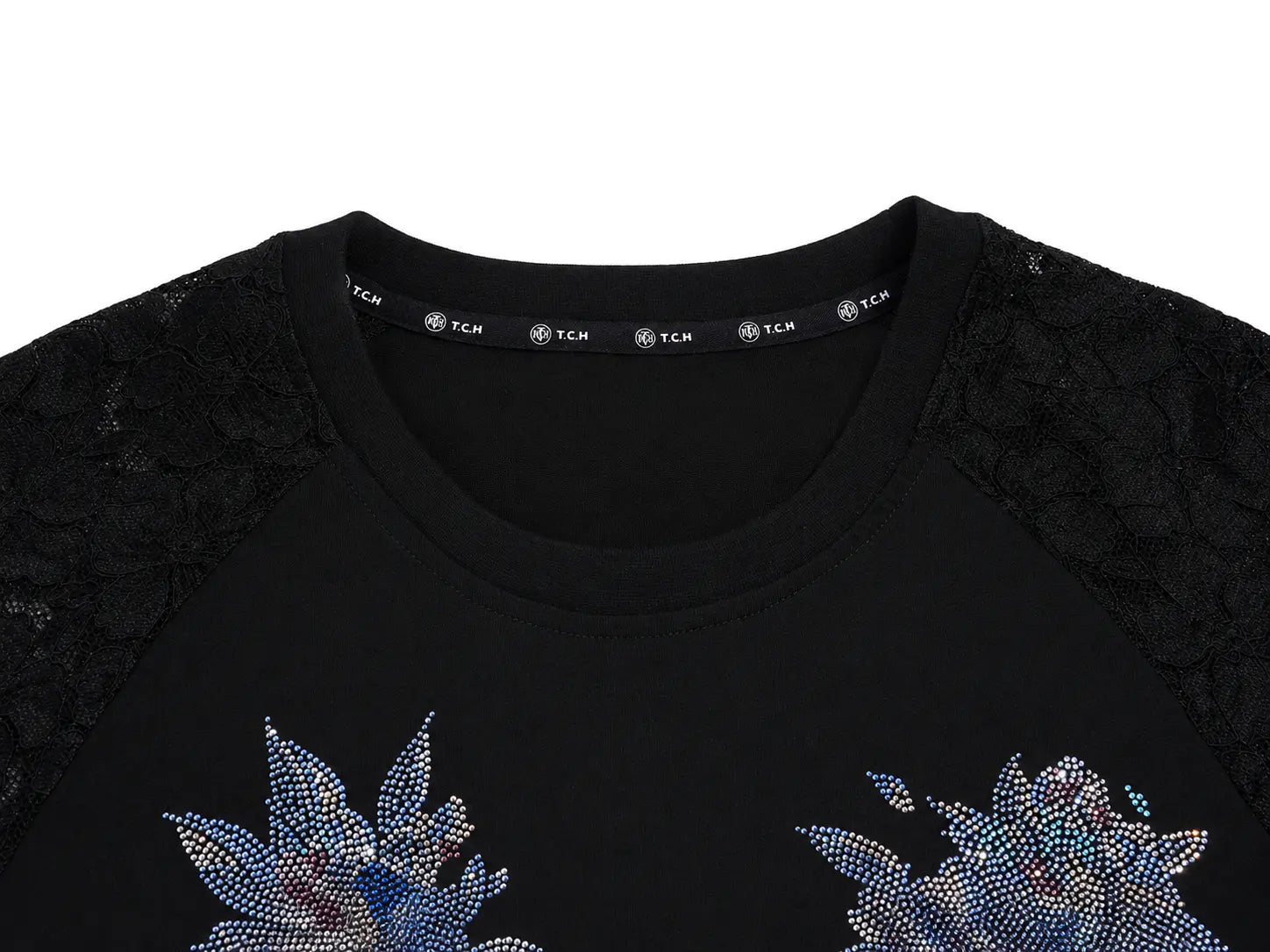 Close-up of a black crewneck top with black lace sleeves and blue rhinestone floral embellishments on the chest, shown against a white background. TCH Rhinestone Floral Wing Techno Graphic T-Shirt