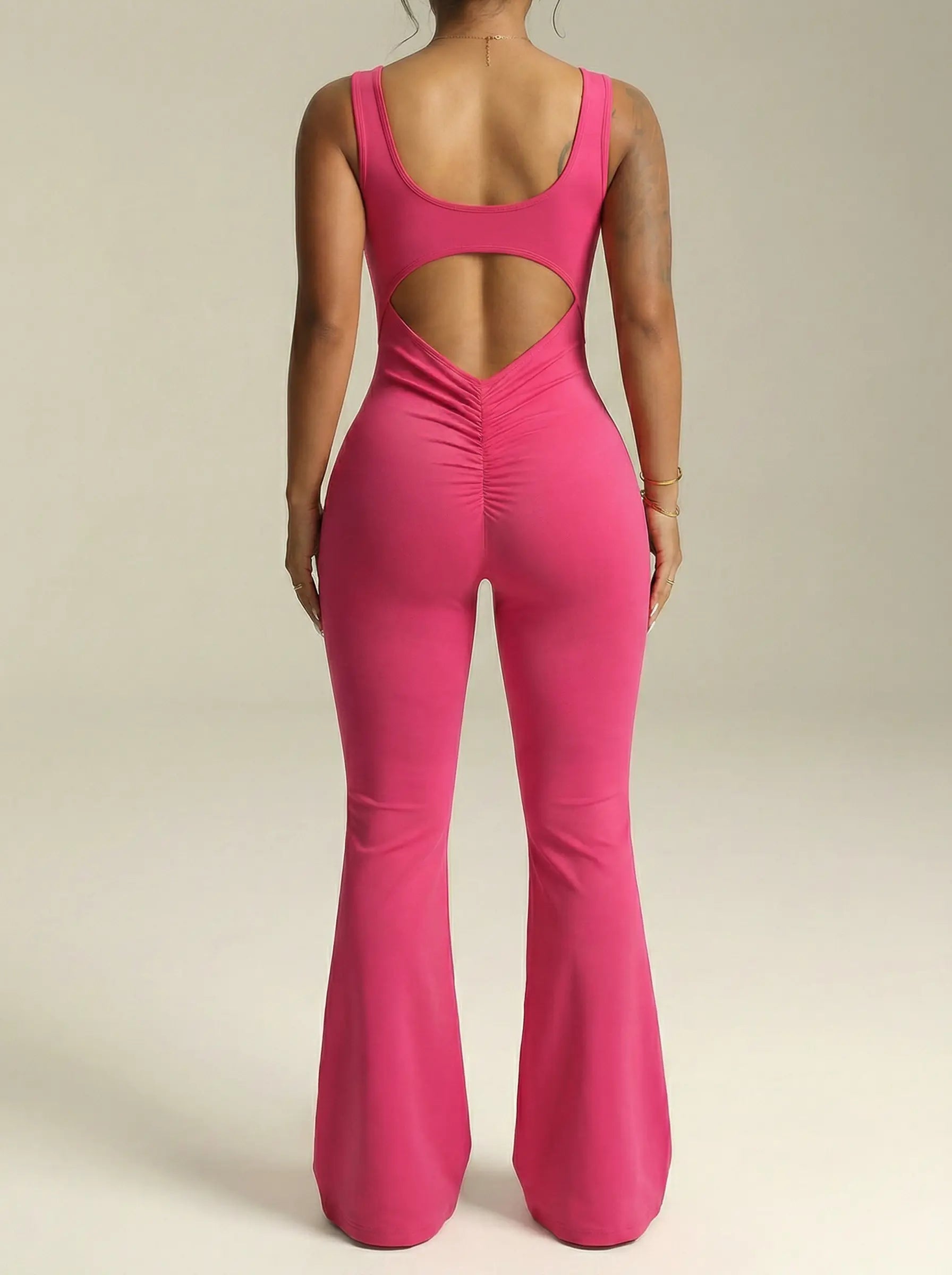Pink jumpsuit with cut-out back on a neutral background， TCH Rhinestone Floral Wing Yoga Jumpsuit-1