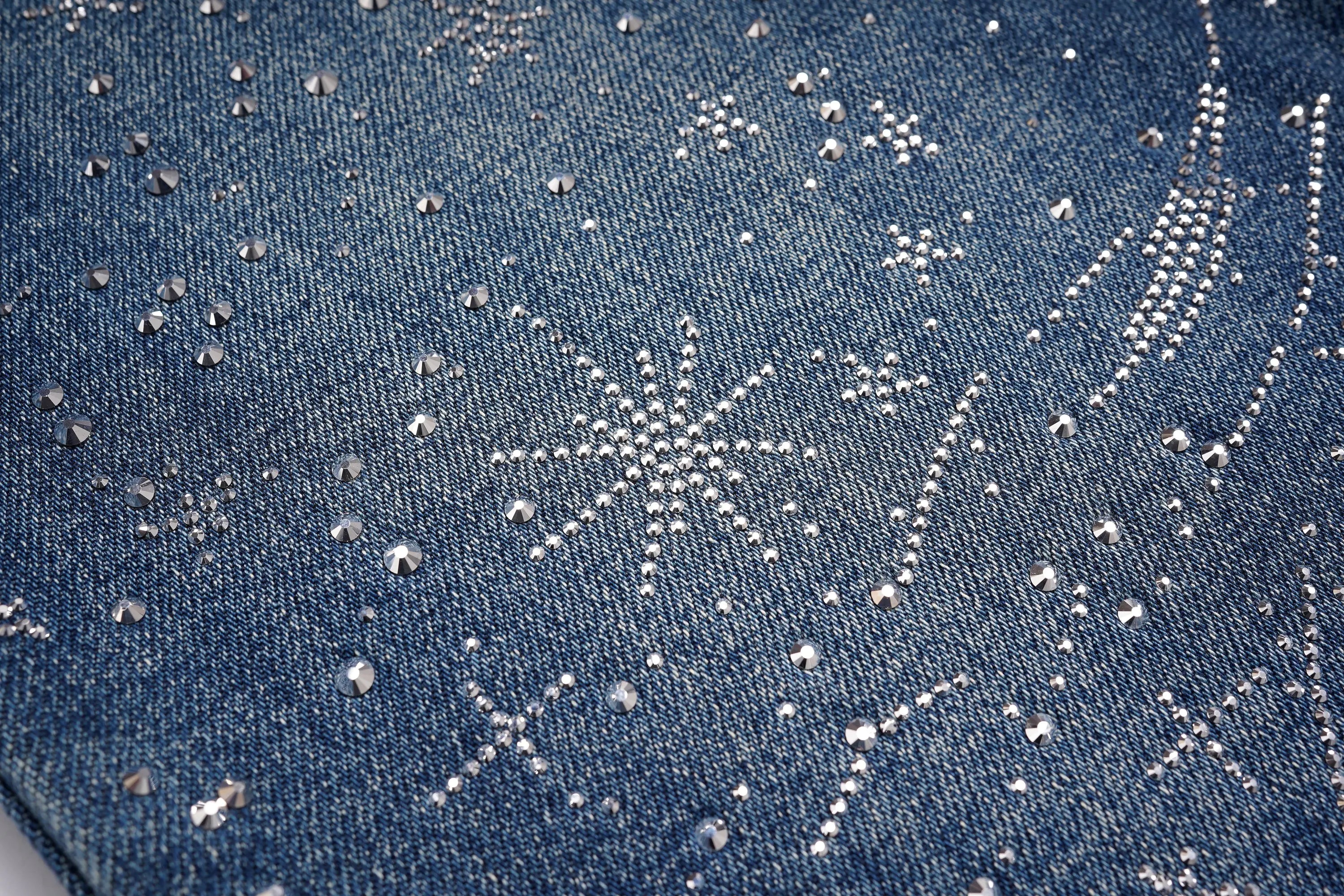 Close-up of blue denim fabric with silver embroidery patterns, TCH Rhinestone Galaxy Sparkle Wide-Leg Jeans