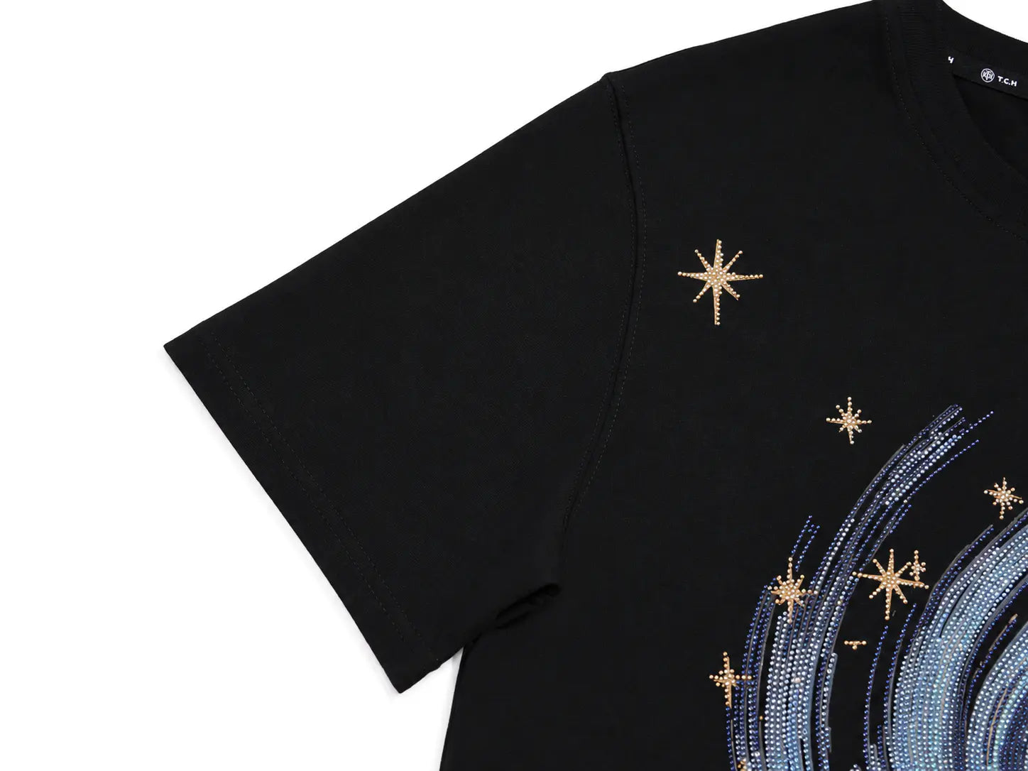 Close-up of a black short-sleeve T-shirt with gold star embellishments and a blue sequined wave graphic on a white background. TCH Rhinestone Galaxy Spiral Graphic Black T-Shirt