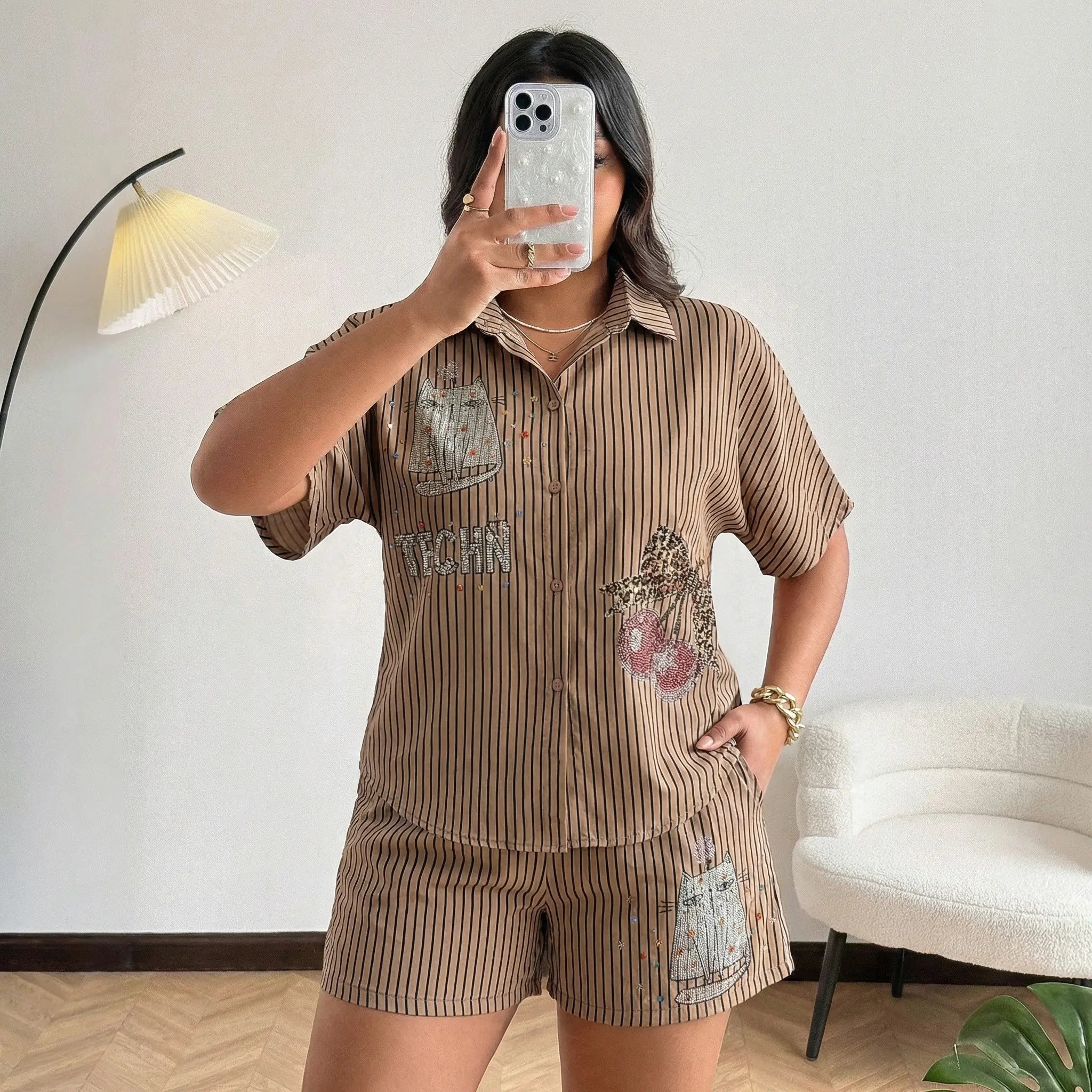 Person wearing a brown corduroy outfit with floral and text designs, taking a mirror selfie. TCH Rhinestone Graffiti Cat & Cherry Set