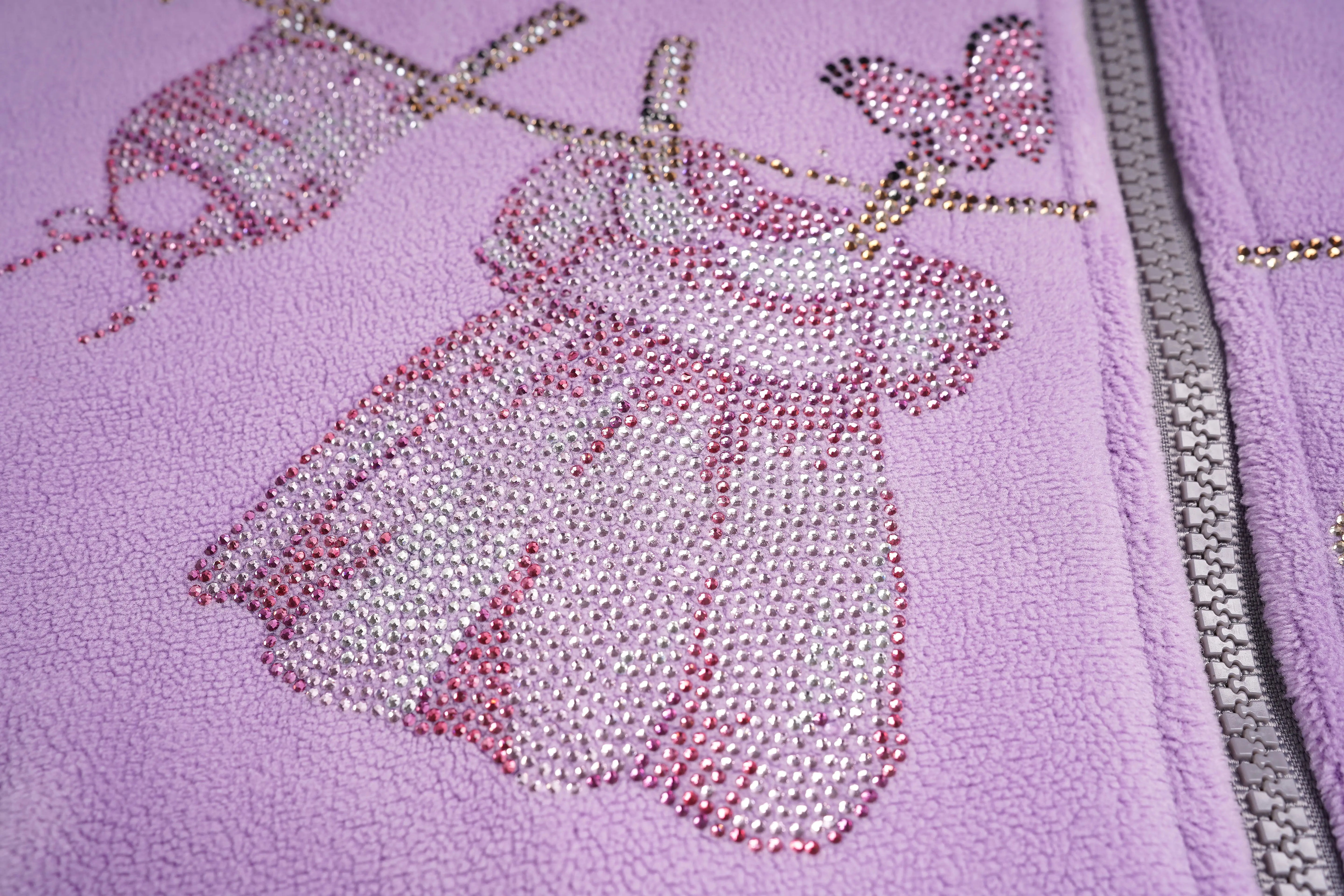 Close-up of a purple fabric with butterfly embellishments on a pink background, TCH Rhinestone Laundry Line Purple Zip Turtleneck Set