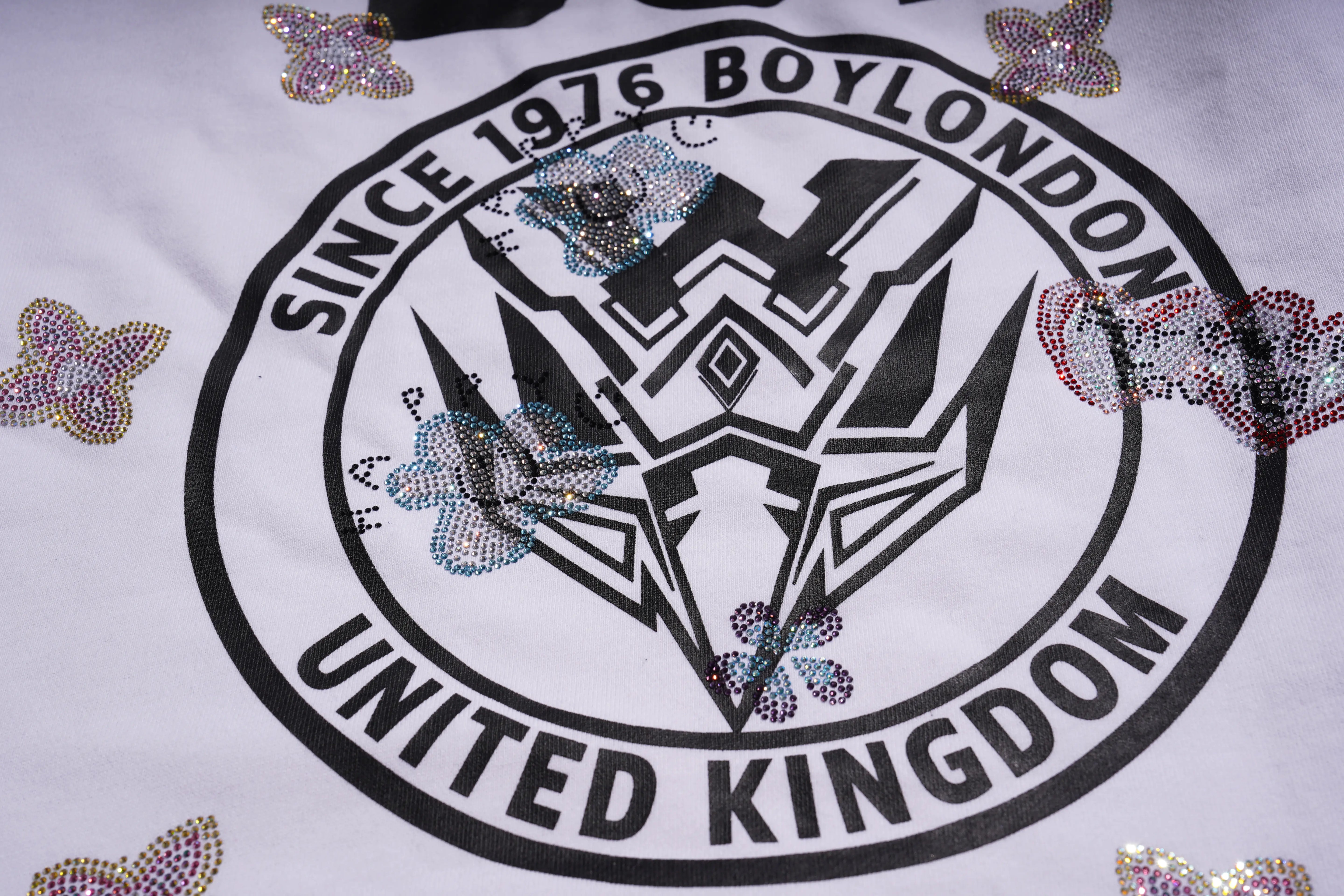 Logo with text 'Since 1976 Boylondon United Kingdom' on a white background with decorative elements. TCH Rhinestone Logo Print Crew Neck Sweatshirt