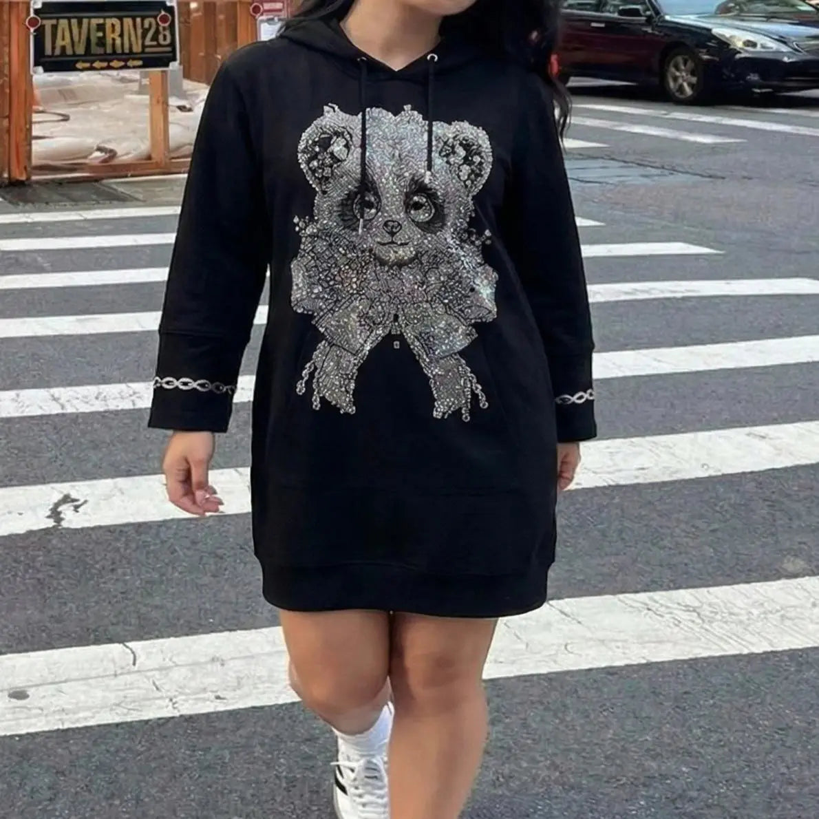 Person wearing a black hoodie with a decorative design on a street. TCH Rhinestone Panda Bow Dress