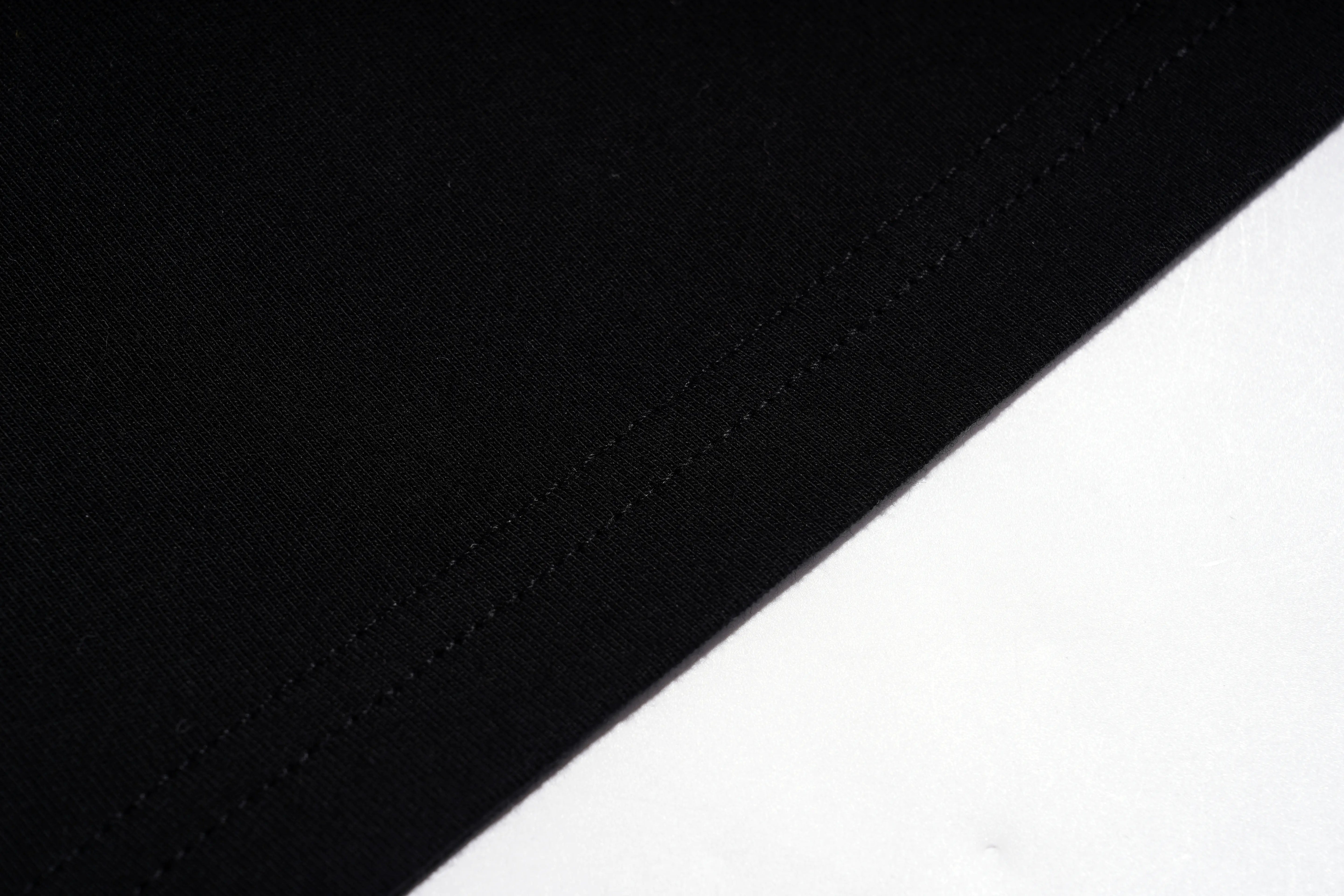 Close-up of a black textile material with a diagonal seam, showing fine woven texture against a white background. TCH Rhinestone Panda Graphic Sleeveless T-Shirt