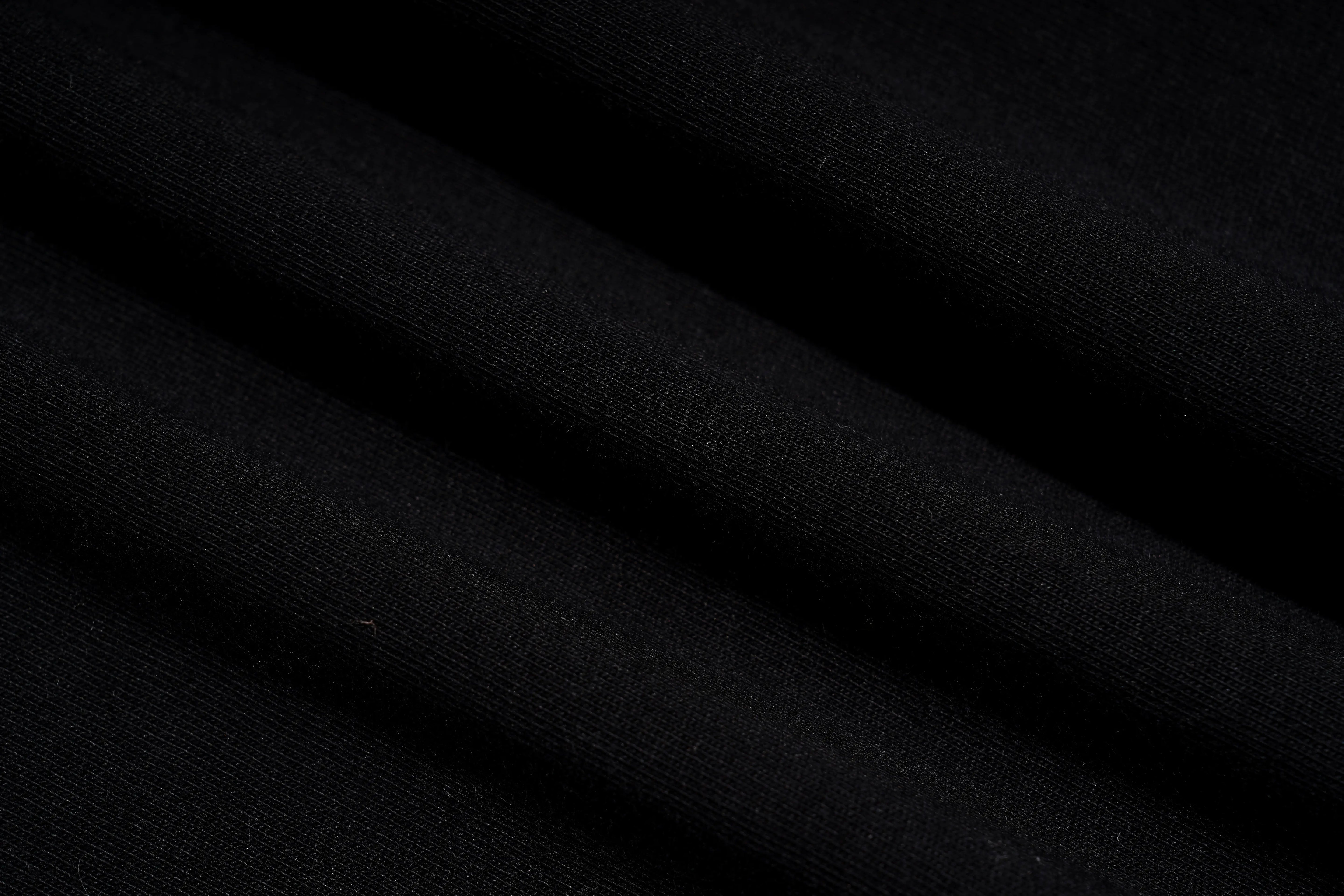 A close-up of draped black fabric with soft folds and a fine knit texture. TCH Rhinestone Panda Graphic Sleeveless T-Shirt