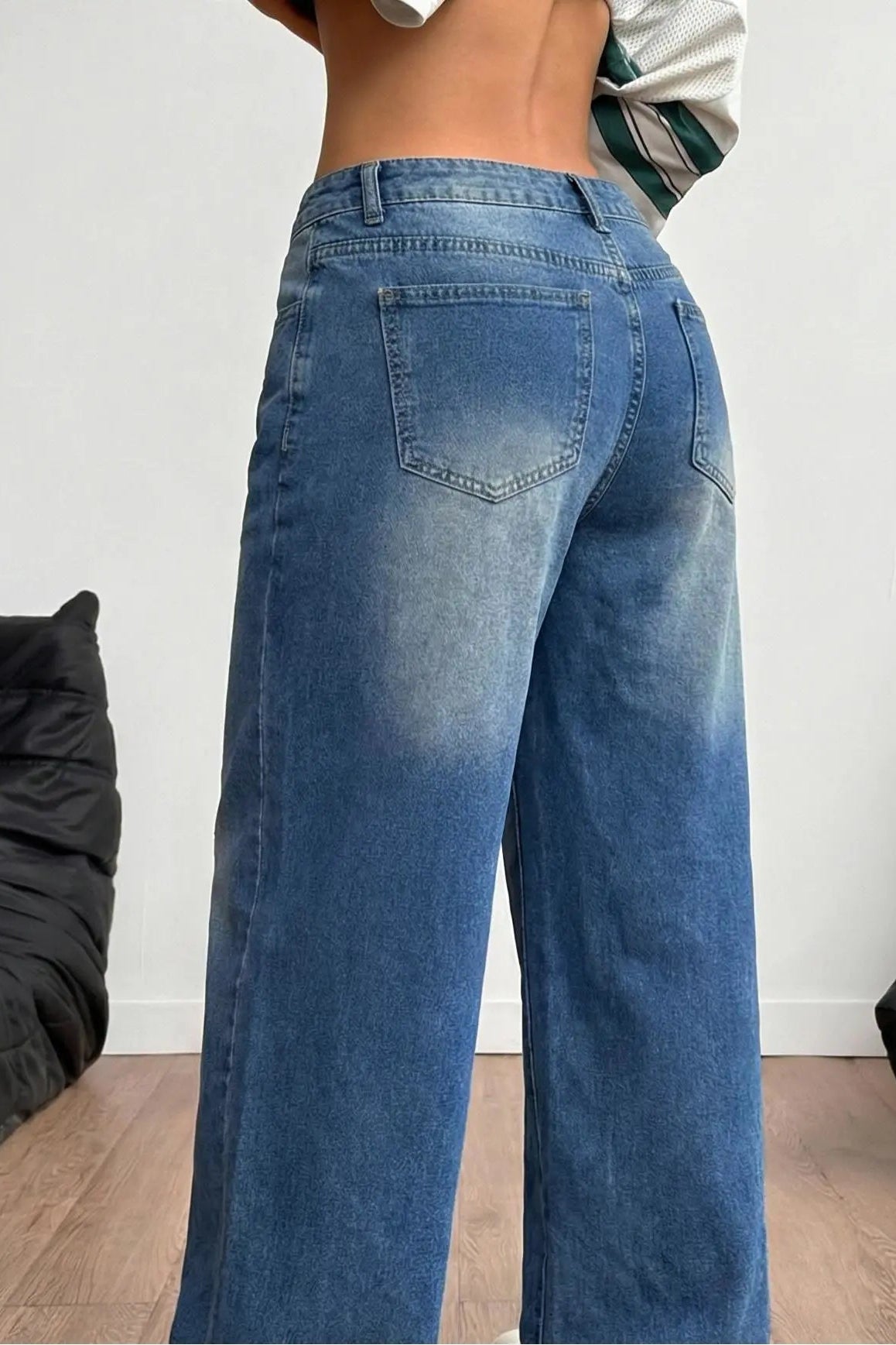 Person wearing blue jeans standing in a room with black bean bags. TCH Rhinestone Pendant Allover Denim Jeans