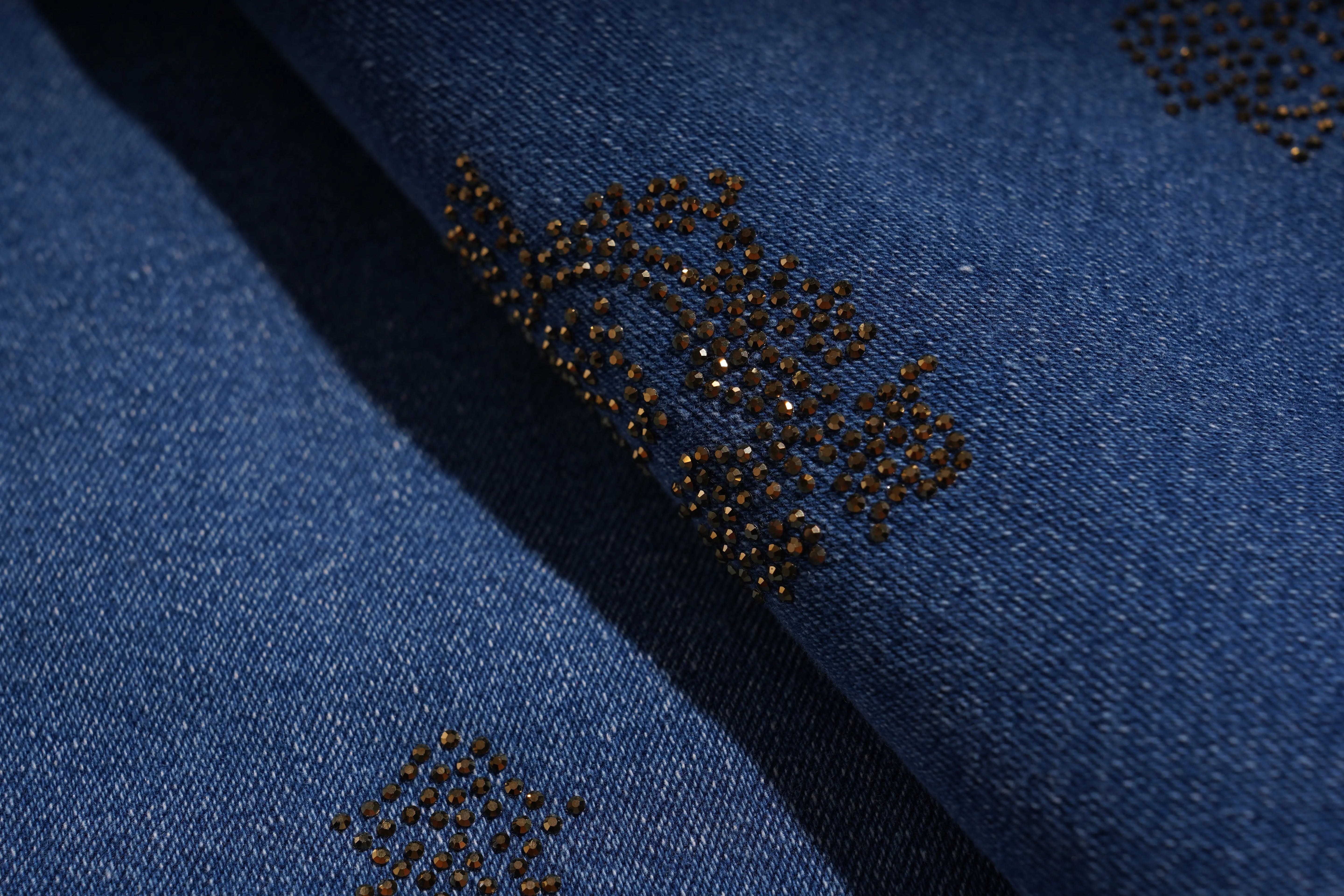 Close-up of blue fabric with decorative black bead pattern, TCH Rhinestone Pendant Allover Denim Jeans