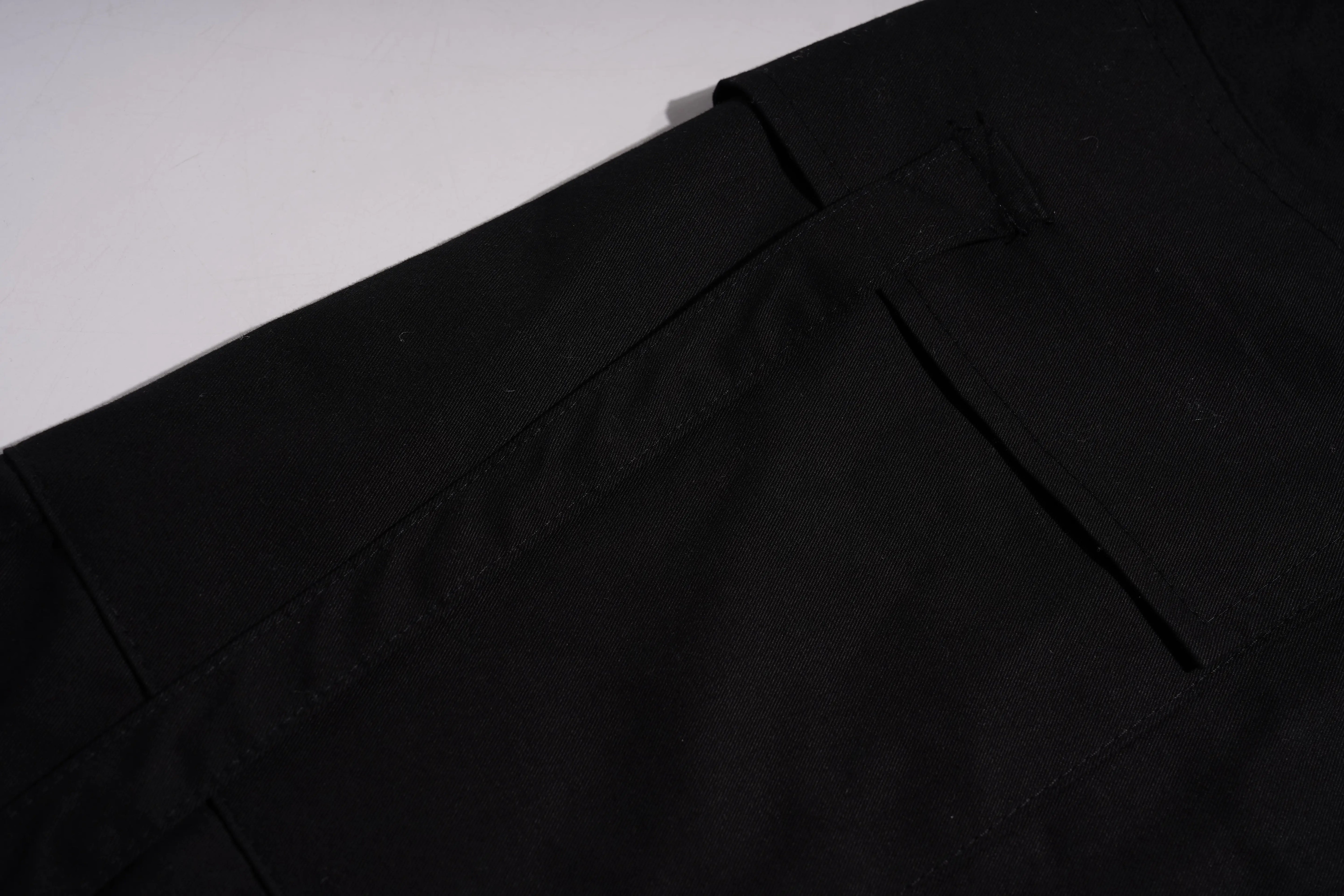 Close-up of black trousers showing the waistband, belt loop, and front seam detail. TCH Rhinestone Phoenix Cargo Wide-Leg Pants