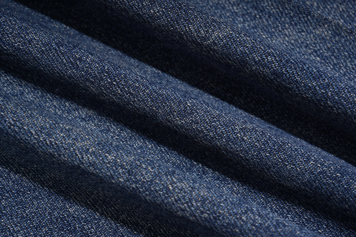 A close-up of dark blue denim fabric with a visible twill weave and soft diagonal folds. TCH Rhinestone Phoenix Wide-Leg Jeans