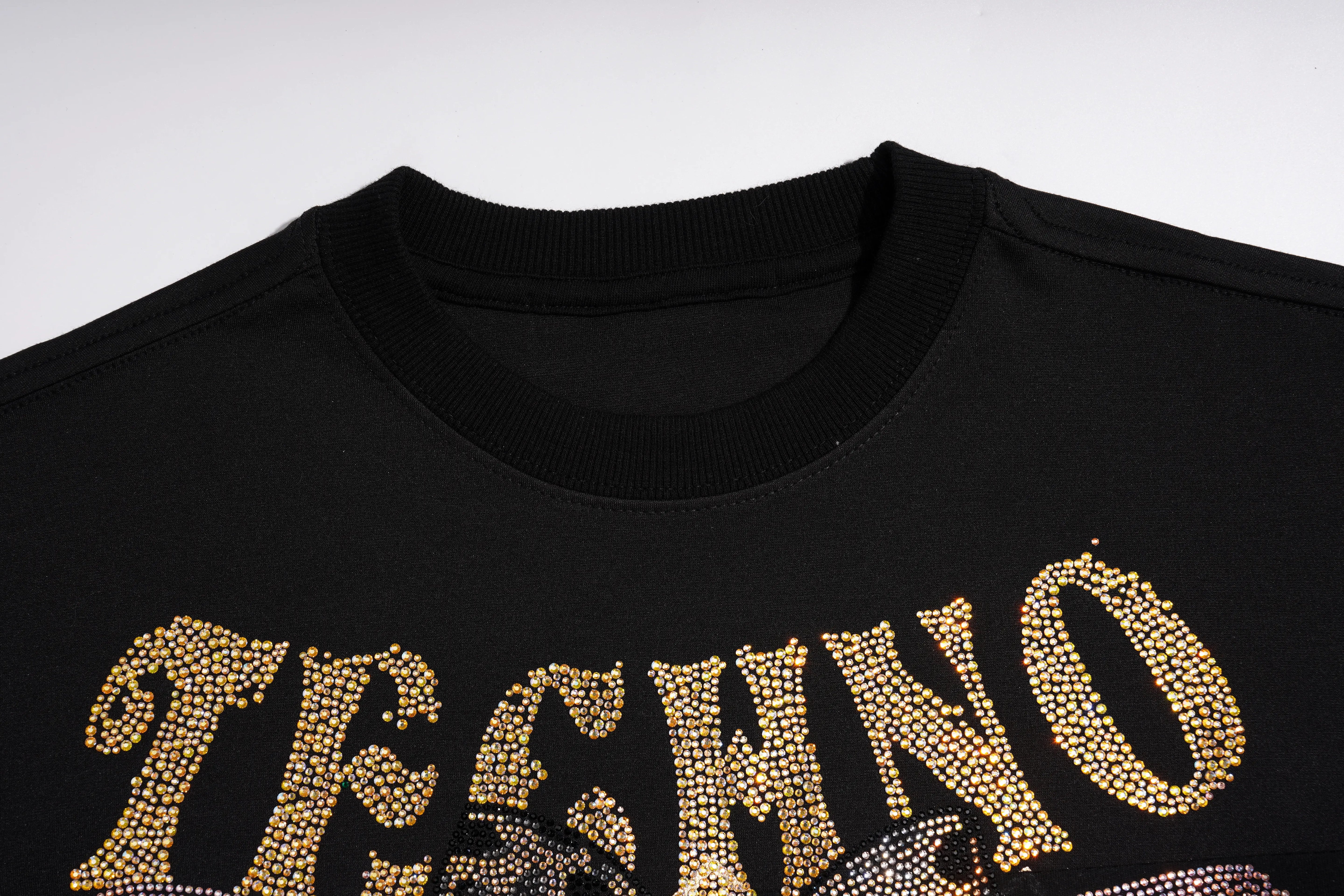 Close-up of a black crewneck t-shirt featuring a large, glittering gold rhinestone-style graphic spelling 'TECHNO' across the chest. TCH Rhinestone Pig Graphic Long Sweatshirt Dress