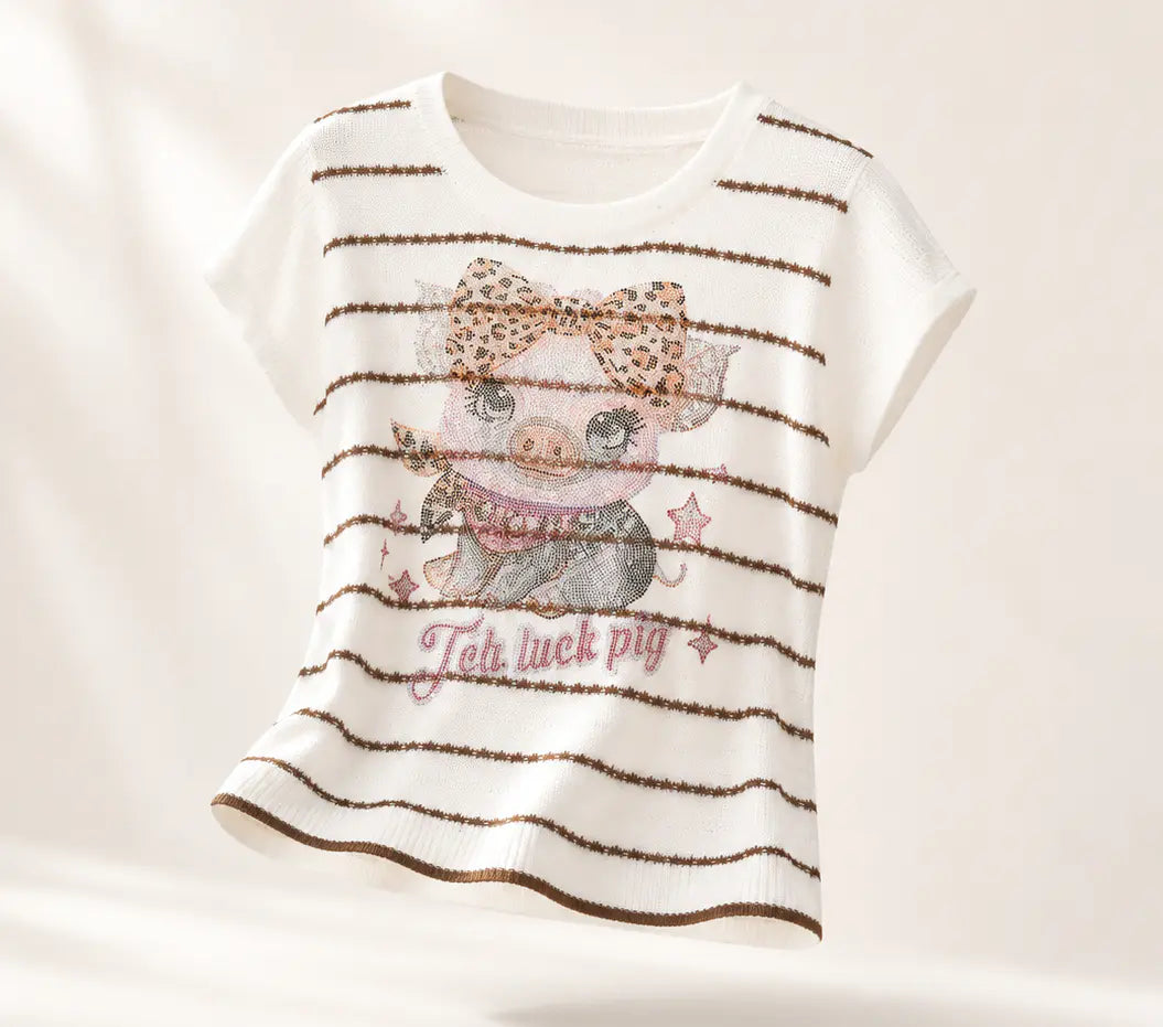 A white short-sleeve t-shirt with thin brown horizontal stripes and a central graphic of a pig wearing a leopard-print bow, styled with the text 'Ten luck pig' in pink script. TCH Rhinestone Piggy Bow Striped Knit Top