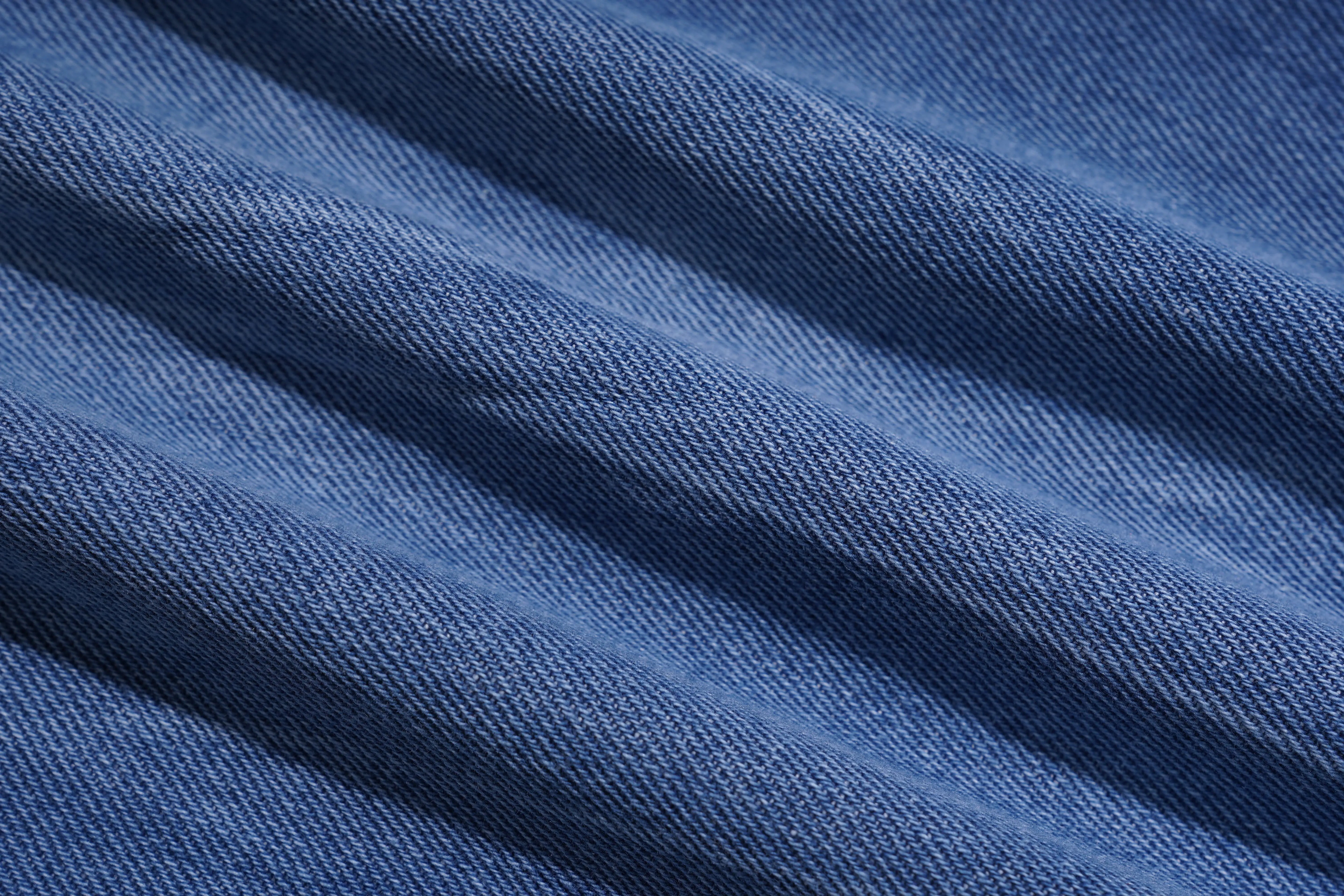 Close-up of blue denim fabric with visible texture, TCH Rhinestone Plum Blossom Tree Distressed Denim Jeans
