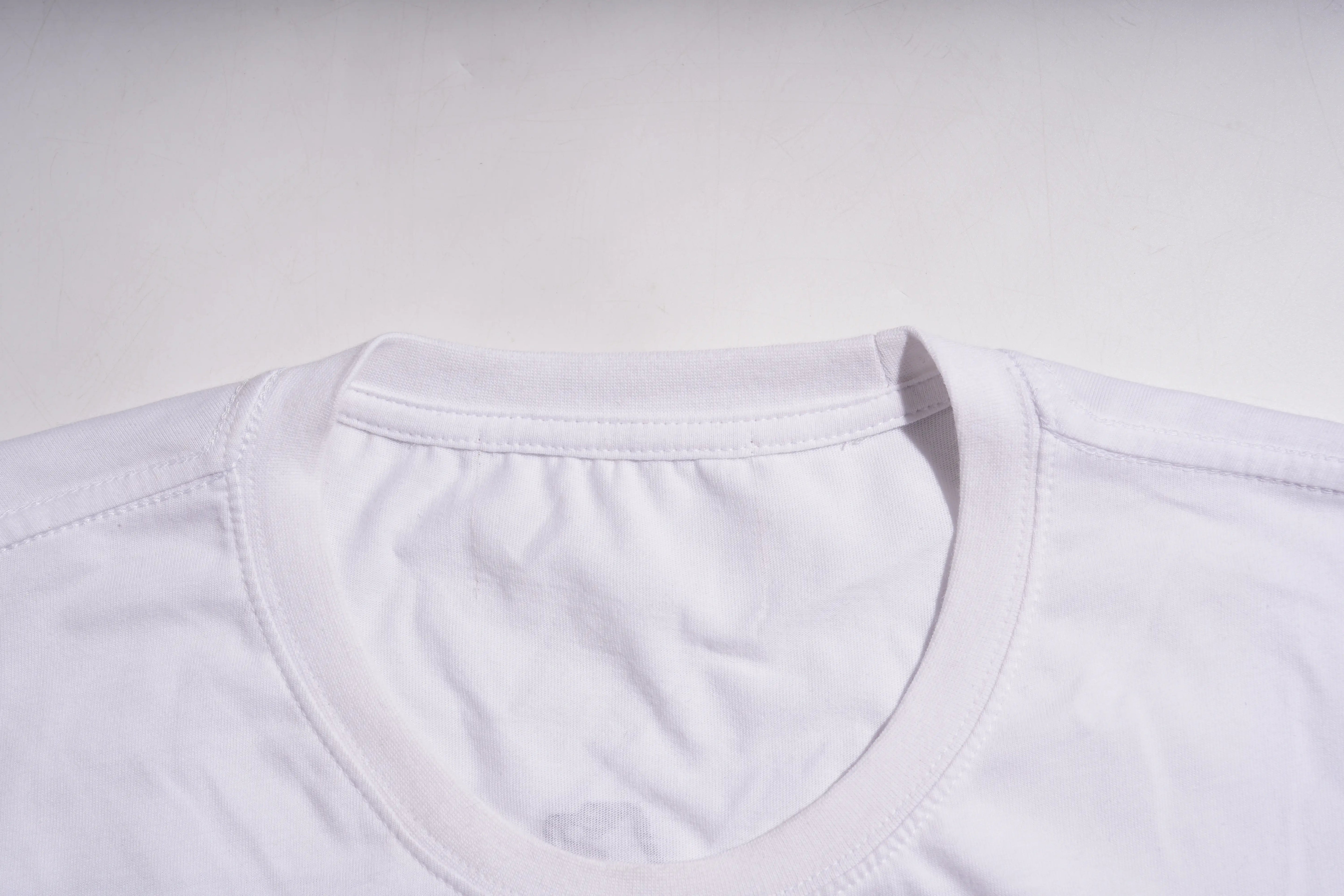 Close-up of a white shirt collar on a light gray background TCH Rhinestone Puppy Bow White T-Shirt-