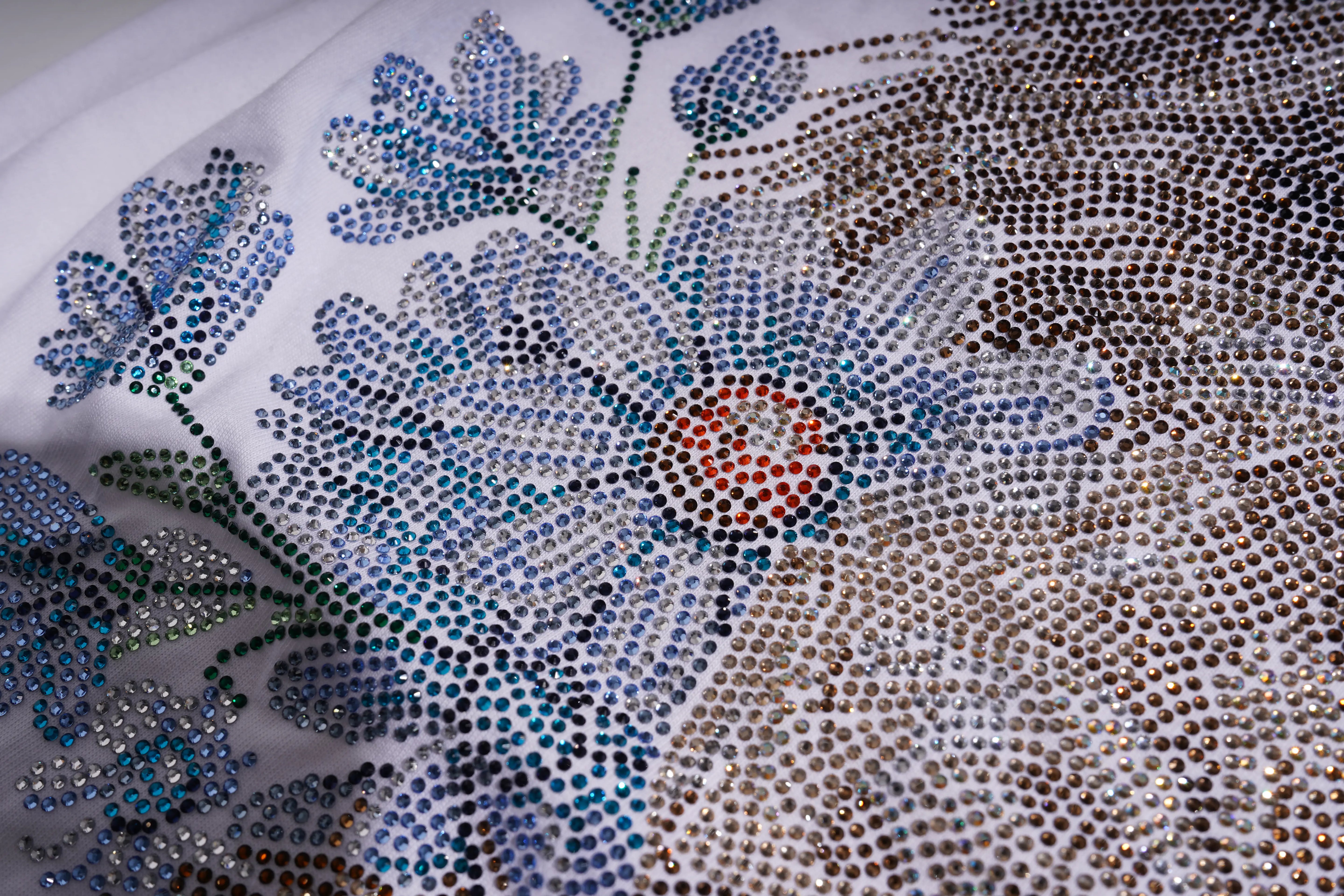 Close-up of a fabric with floral embellishments and rhinestones.