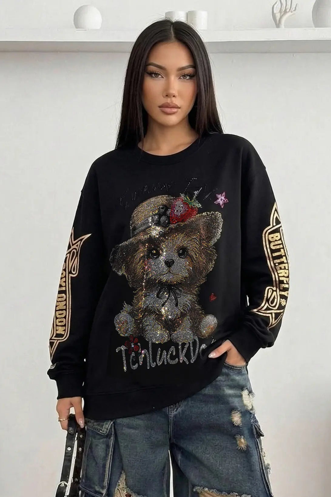 Person wearing a black sweater with a teddy bear design and 'Butterfly' text. TCH Rhinestone Puppy Graphic Sweatshirt-