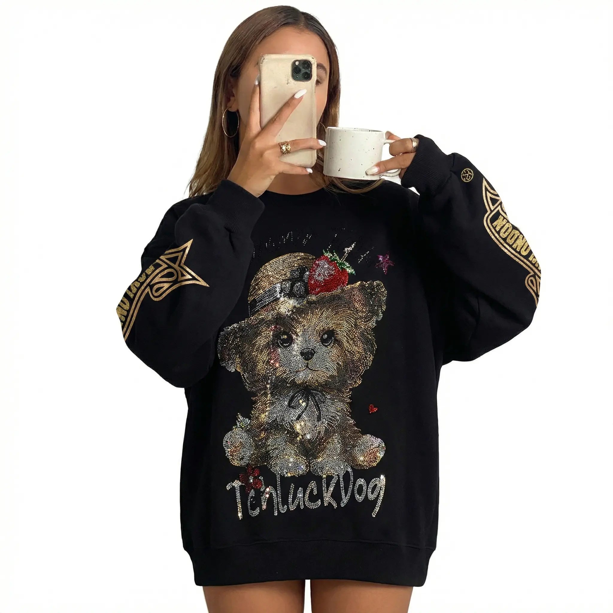 Person wearing a black sweatshirt with a teddy bear graphic and 'Teacup Dog' text, holding a white mug. TCH Rhinestone Puppy Graphic Sweatshirt-1
