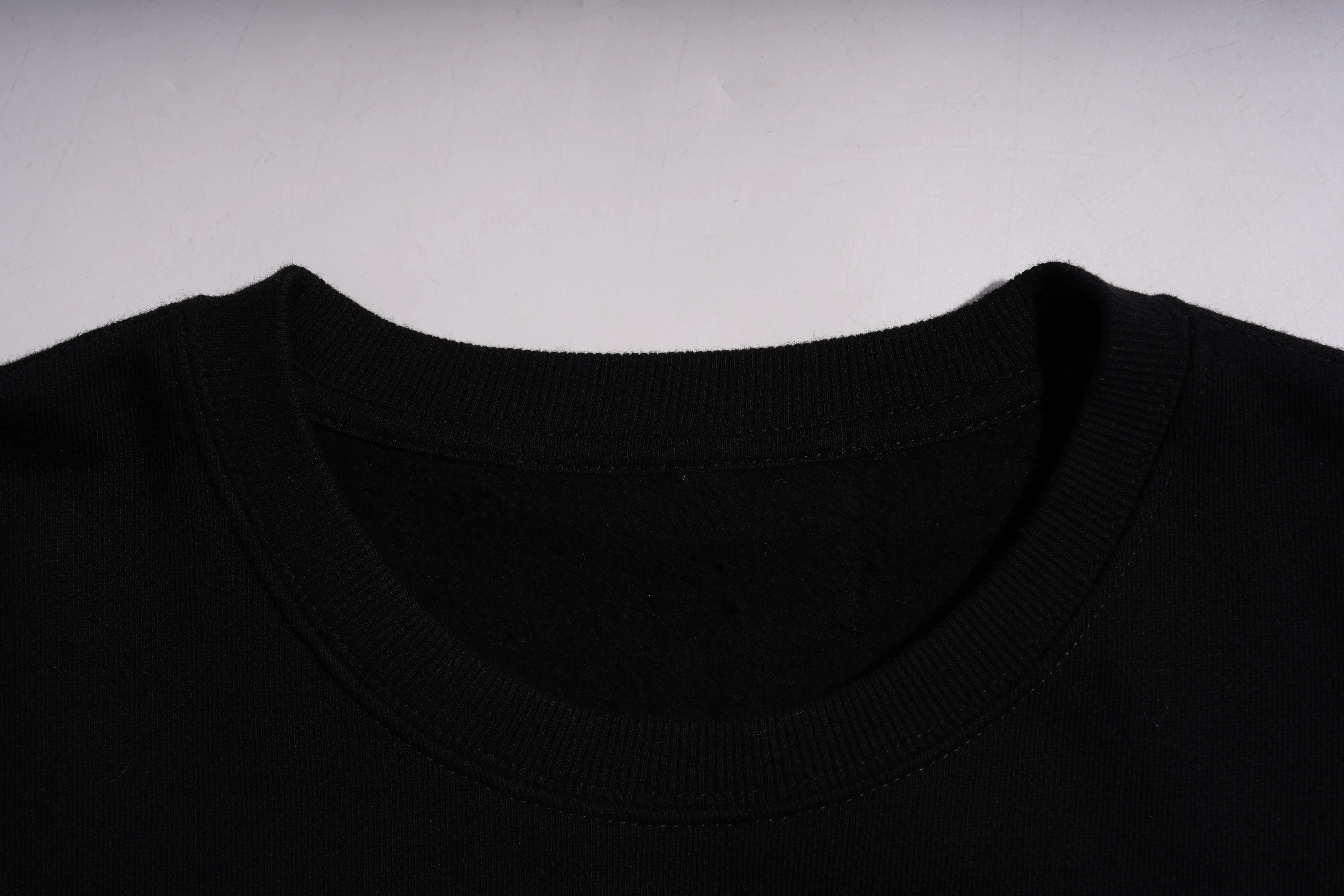 Close-up of a black shirt collar on a light gray background TCH Rhinestone Puppy Graphic Sweatshirt-