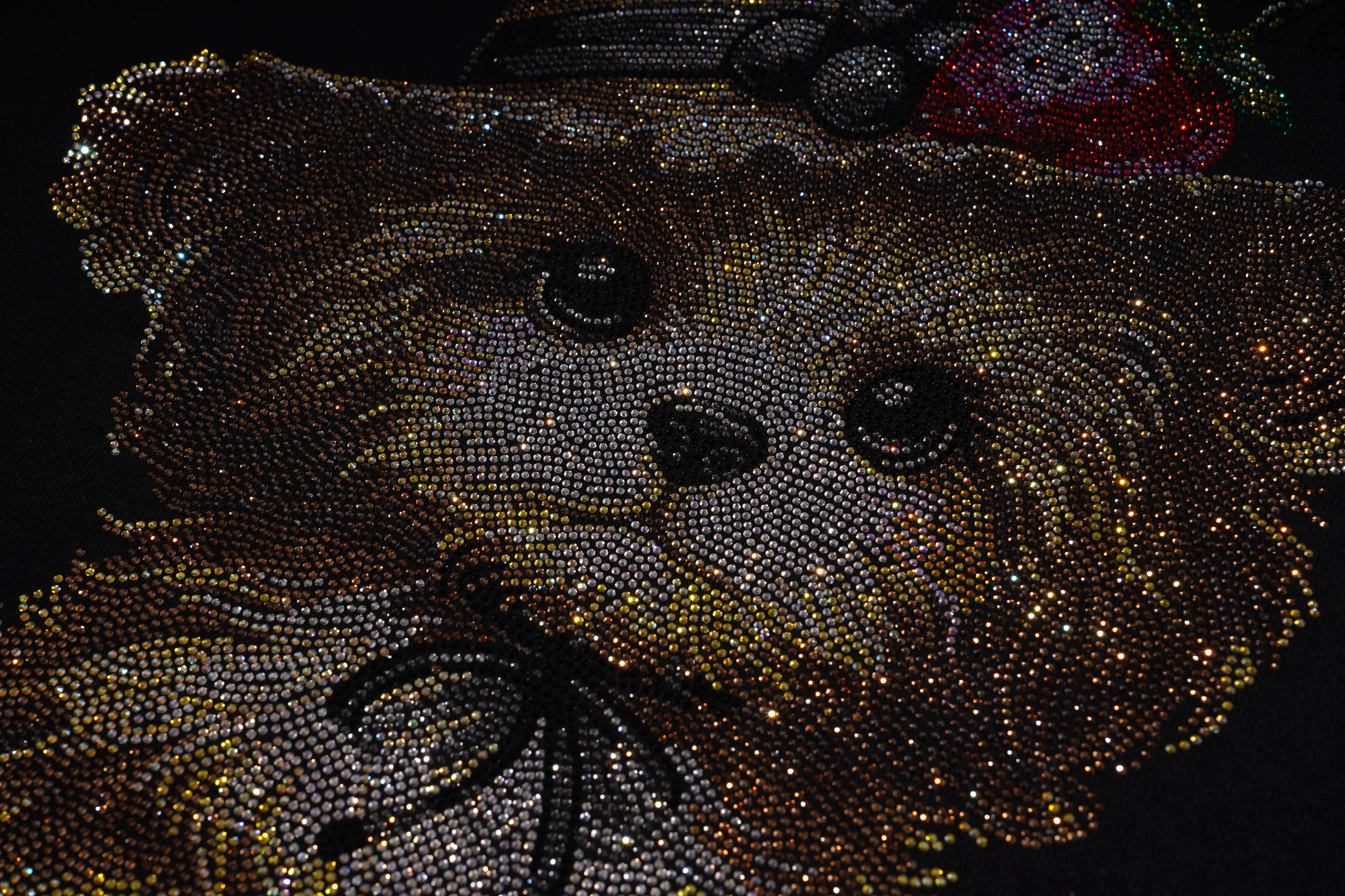 Close-up of a beaded otter design on a dark background. TCH Rhinestone Puppy Graphic Sweatshirt-