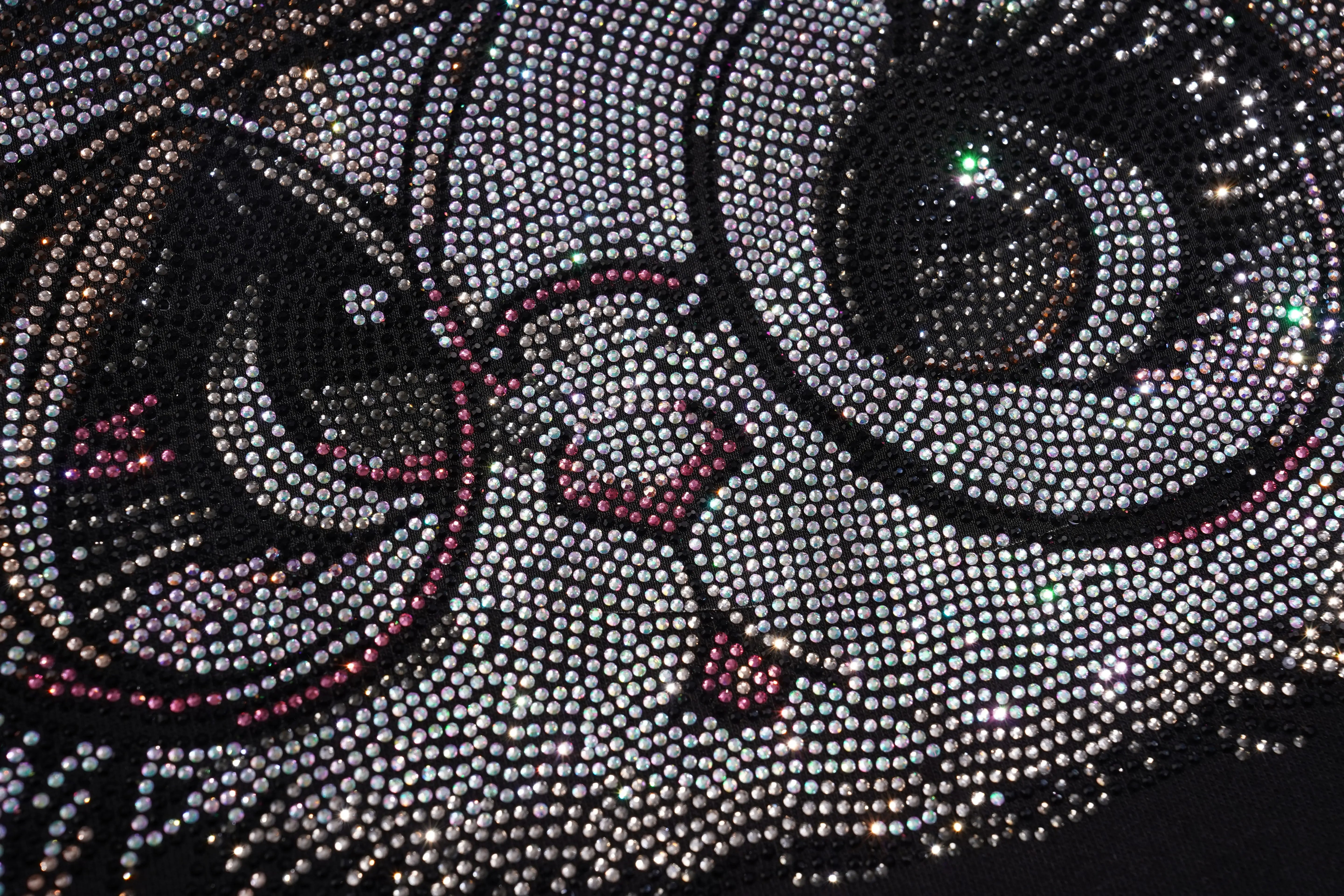 Close-up of a rhinestone-embellished fabric with a cat design. TCH Rhinestone Rabbit Black Red Jersey