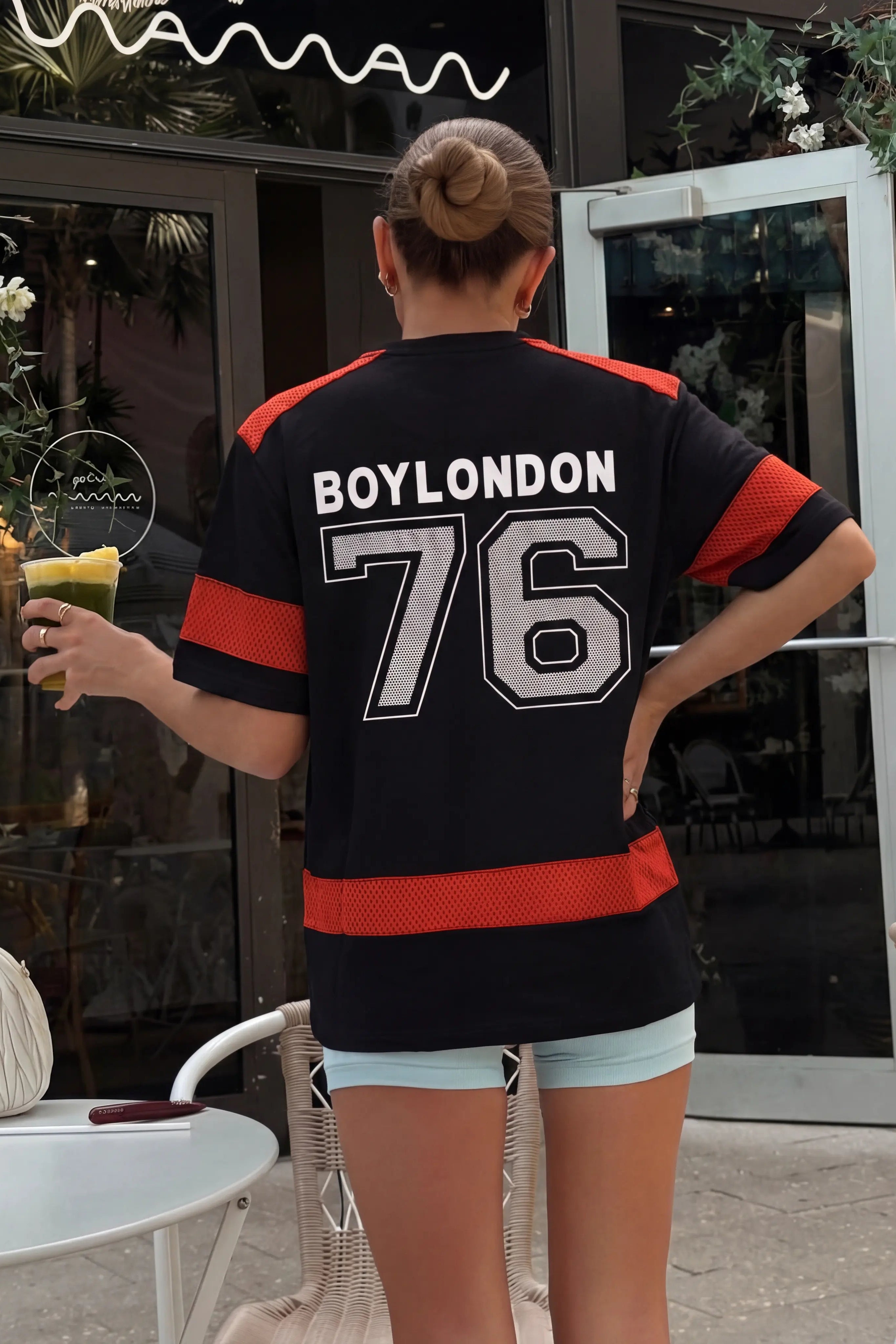 Person wearing a black and red jersey with 'BOYLONDON 76' text, standing outdoors. TCH Rhinestone Rabbit Black Red Jersey