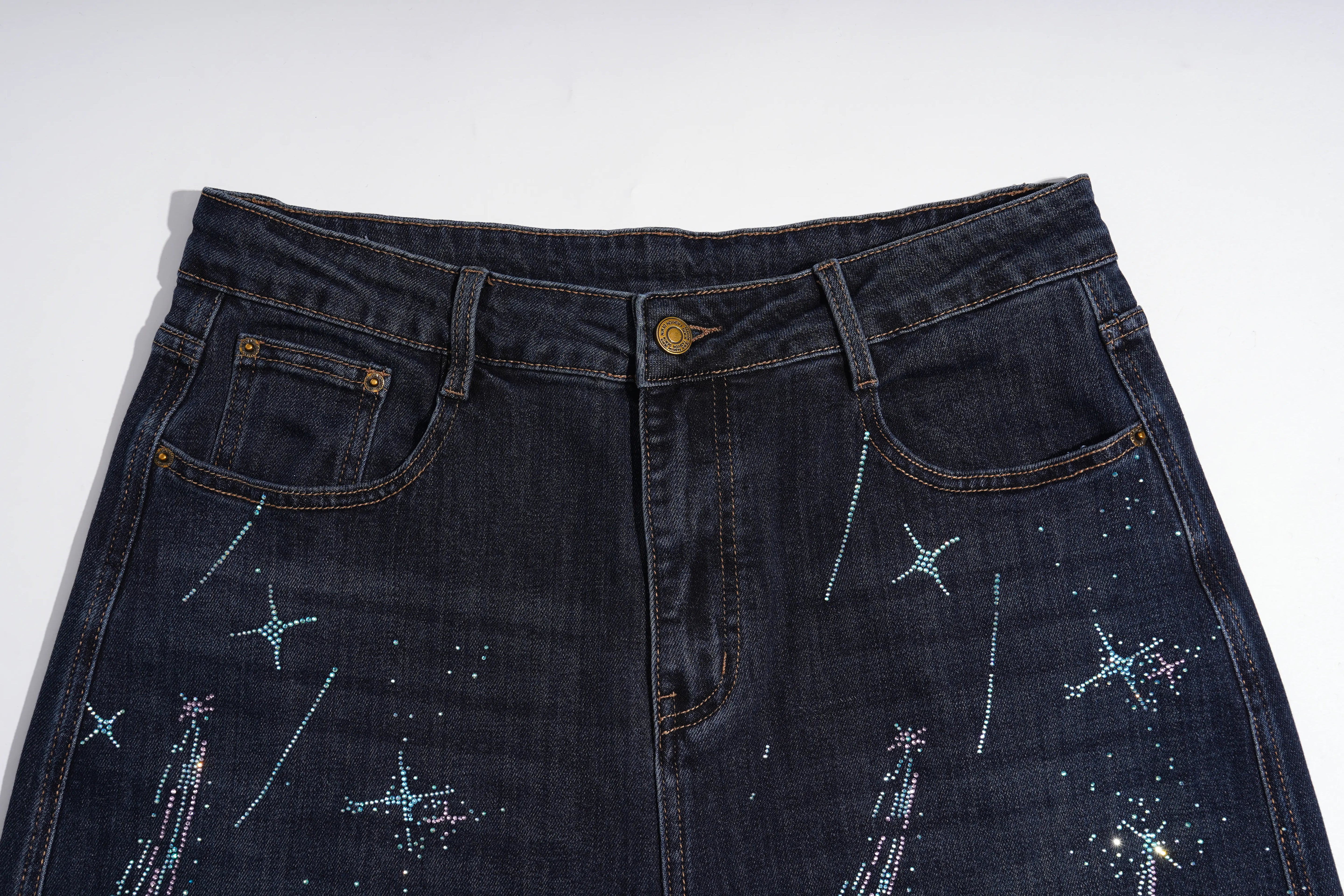 Dark indigo denim jeans featuring embroidered star and firework patterns in light blue and white thread, shown against a plain white background. TCH Rhinestone Shooting Star Galaxy Jeans