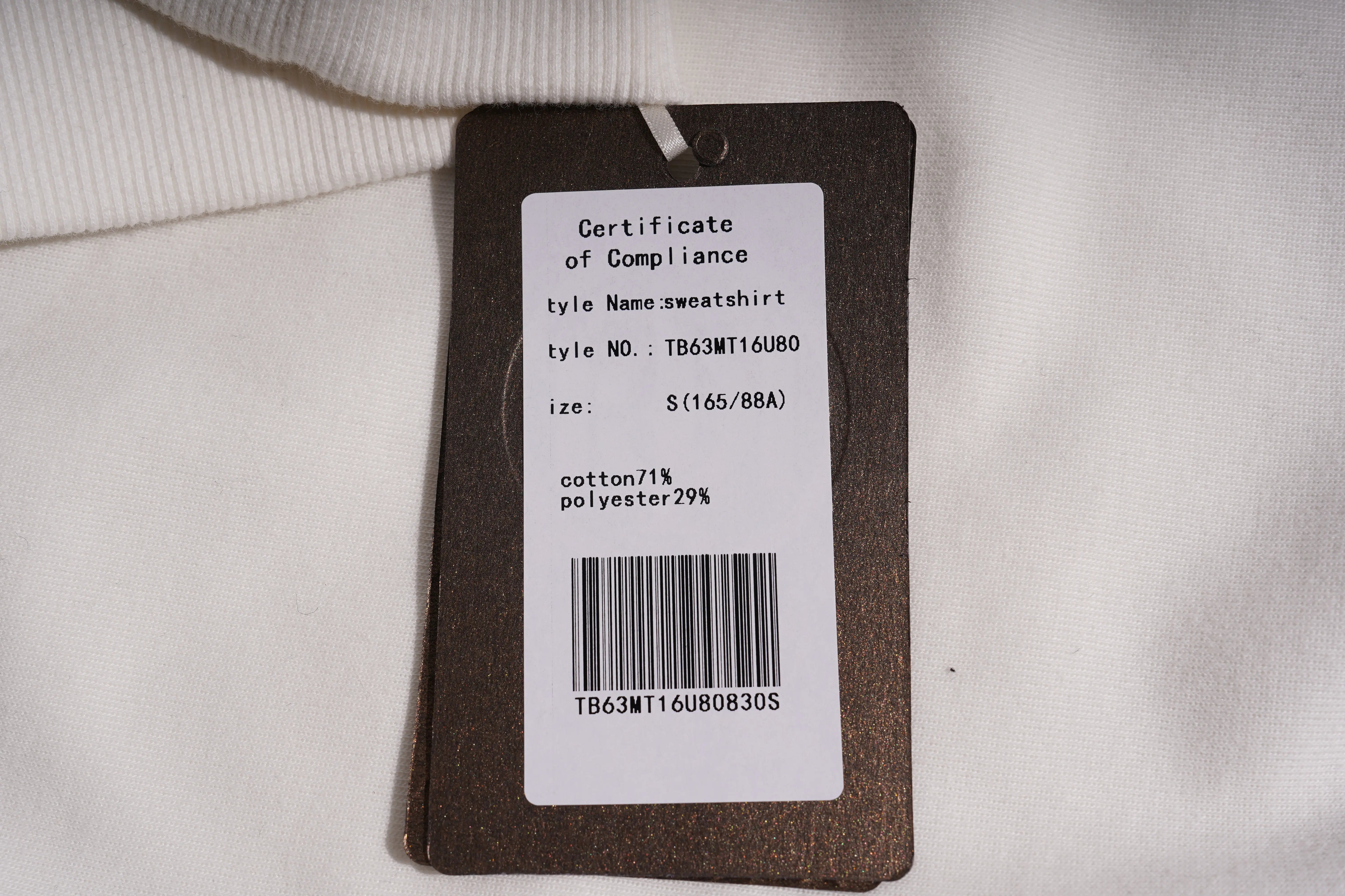 Clothing tag with certificate of compliance and product details on a light background TCH Rhinestone Shooting Star Sweatshirt-11