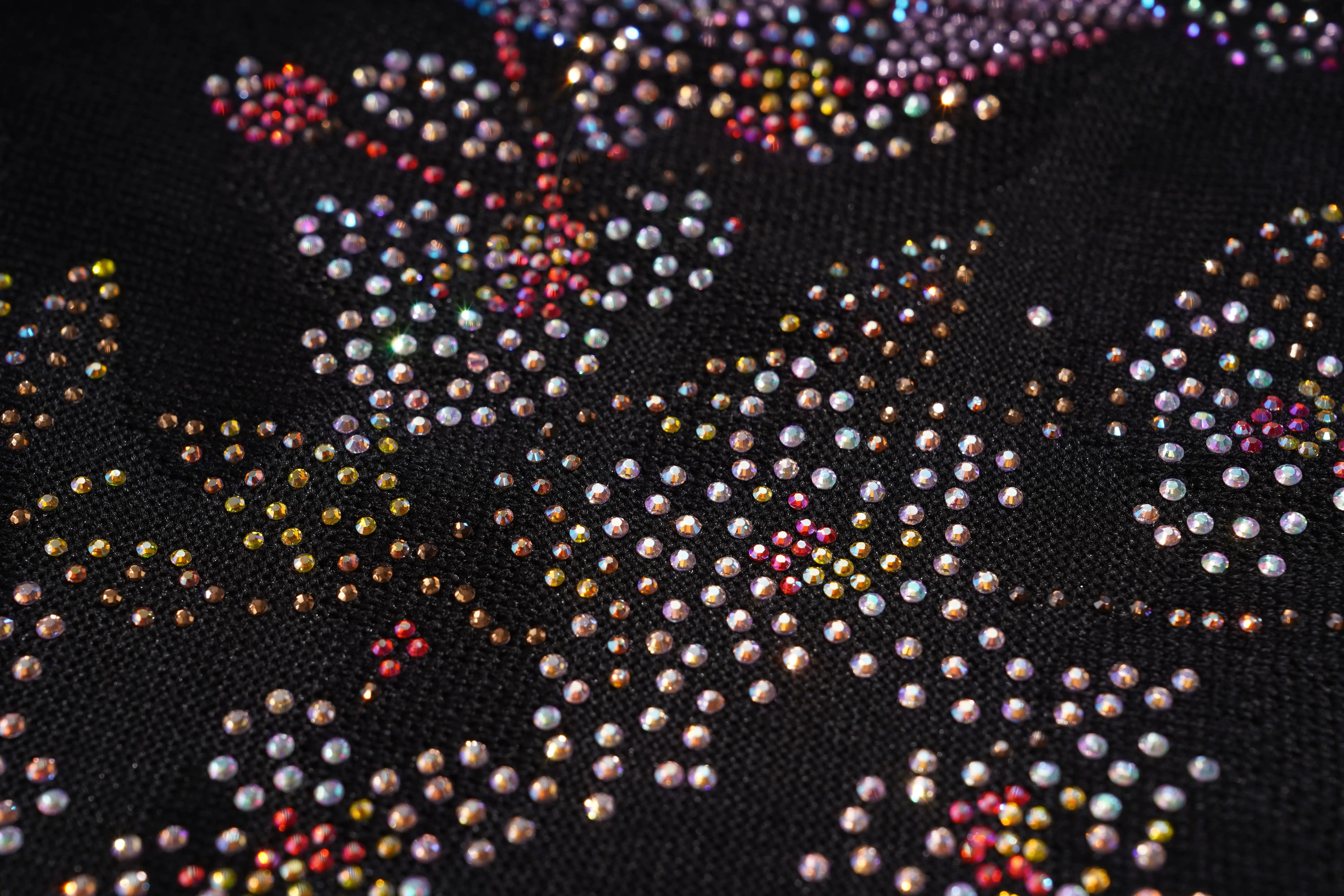 Close-up of a black fabric with colorful rhinestone embellishments, TCH Rhinestone Snake Black Crewneck Sweatshirt