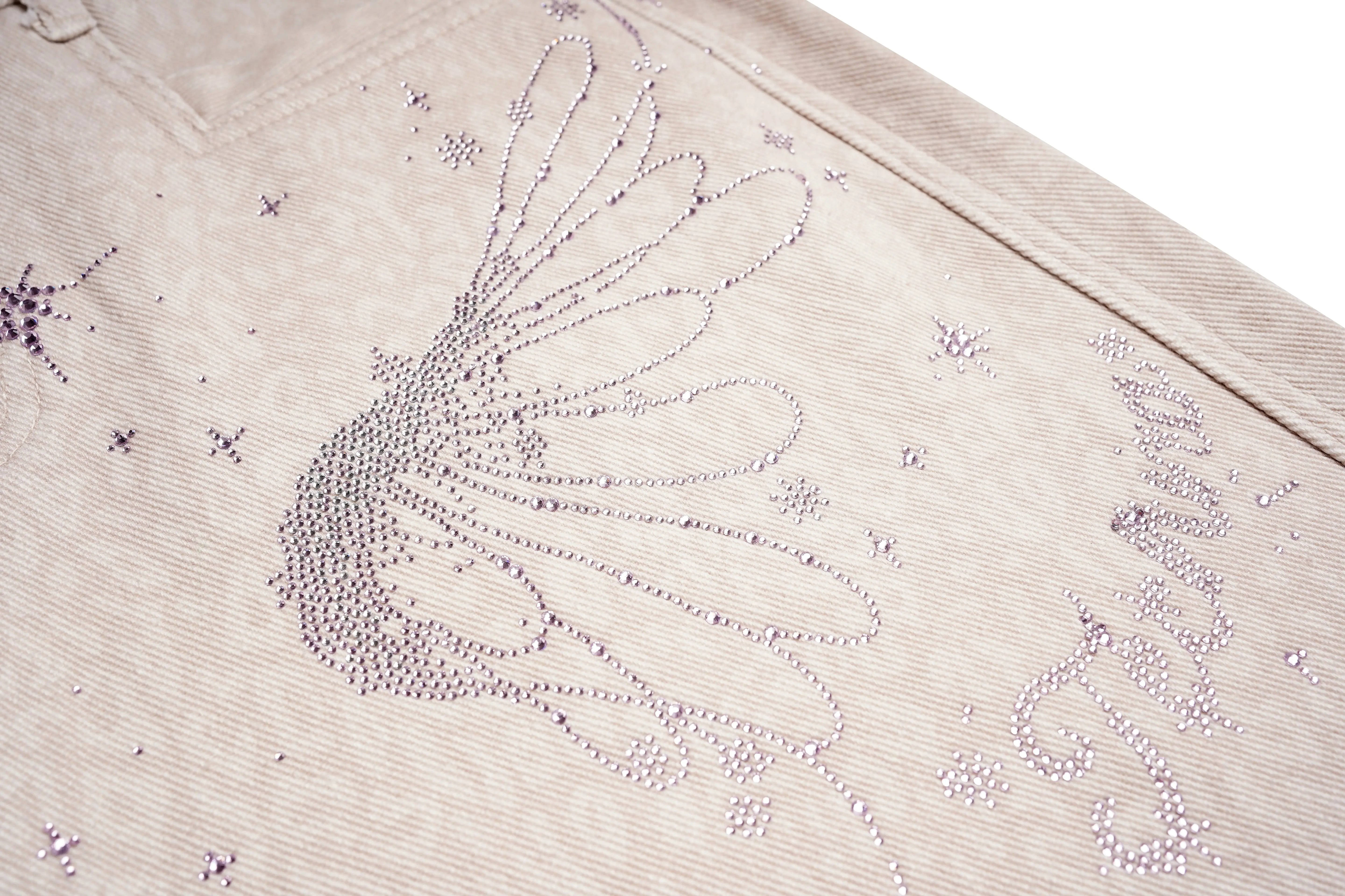 Close-up of a beige fabric with intricate beadwork design on a white background, TCH Rhinestone Star & Angel Wings Beige Denim Jeans