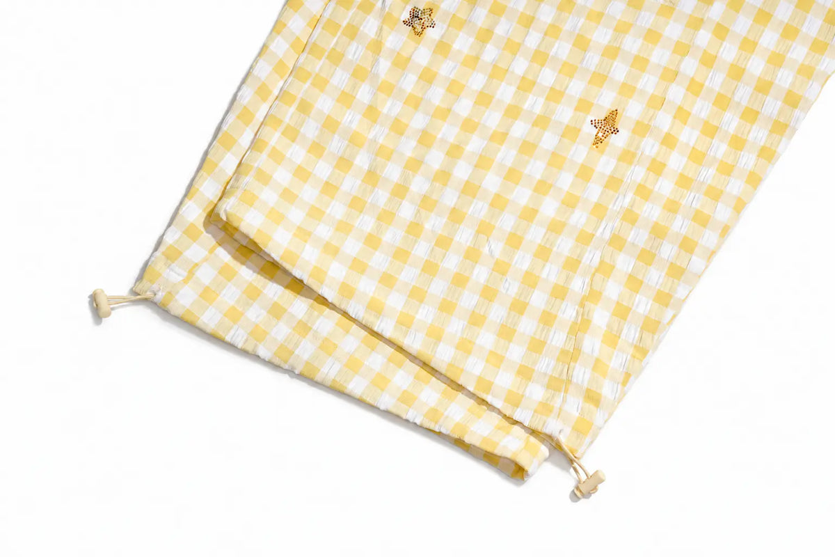 Yellow and white gingham check cotton muslin blanket with small embroidered bees and drawstring ties, shown on a white background. TCH Rhinestone Sunflower Gingham Cargo Wide-Leg Pants