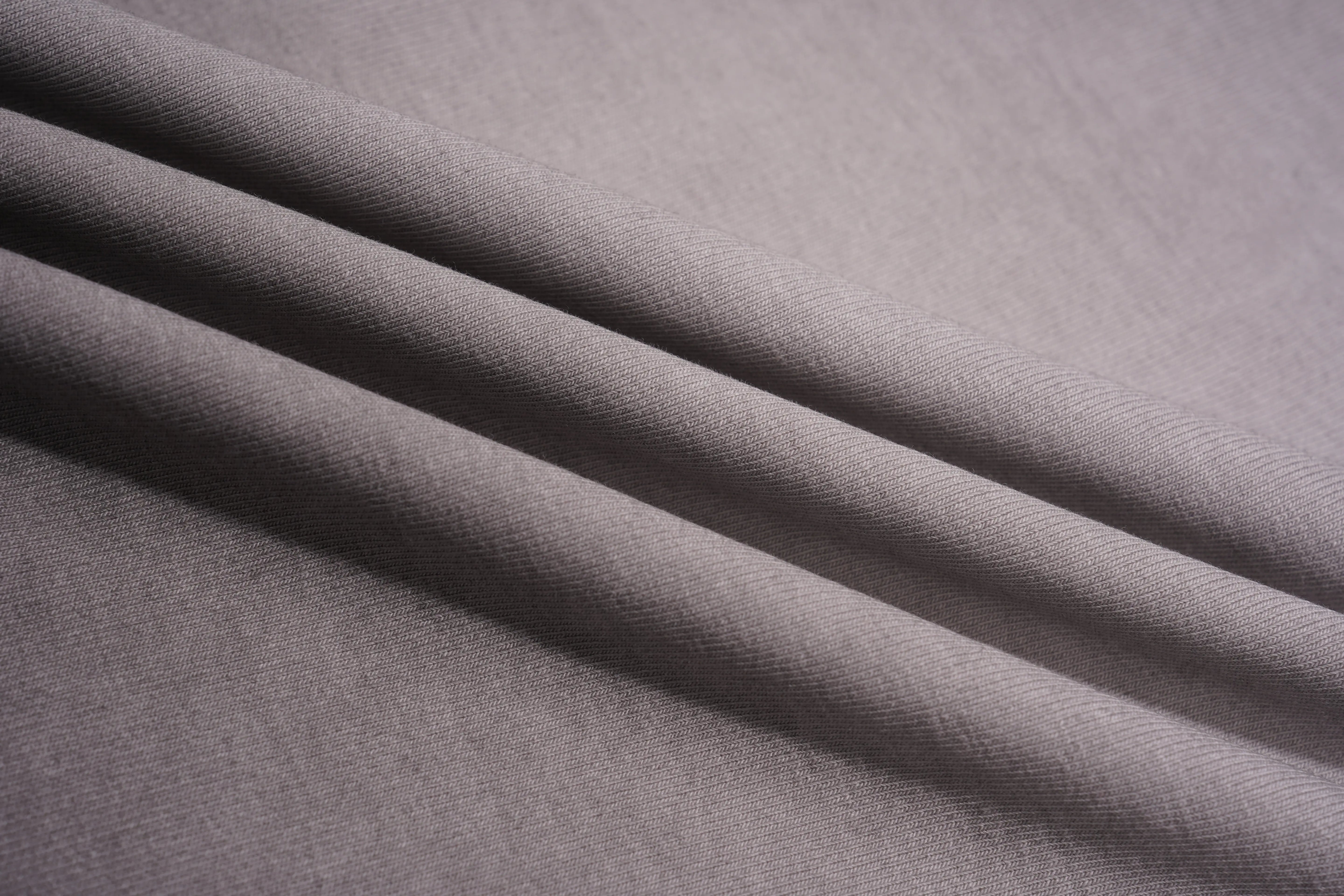 A close-up of draped light gray fabric with soft folds showing its texture and color. TCH Rhinestone TECHNO Graphic Washed T-Shirt