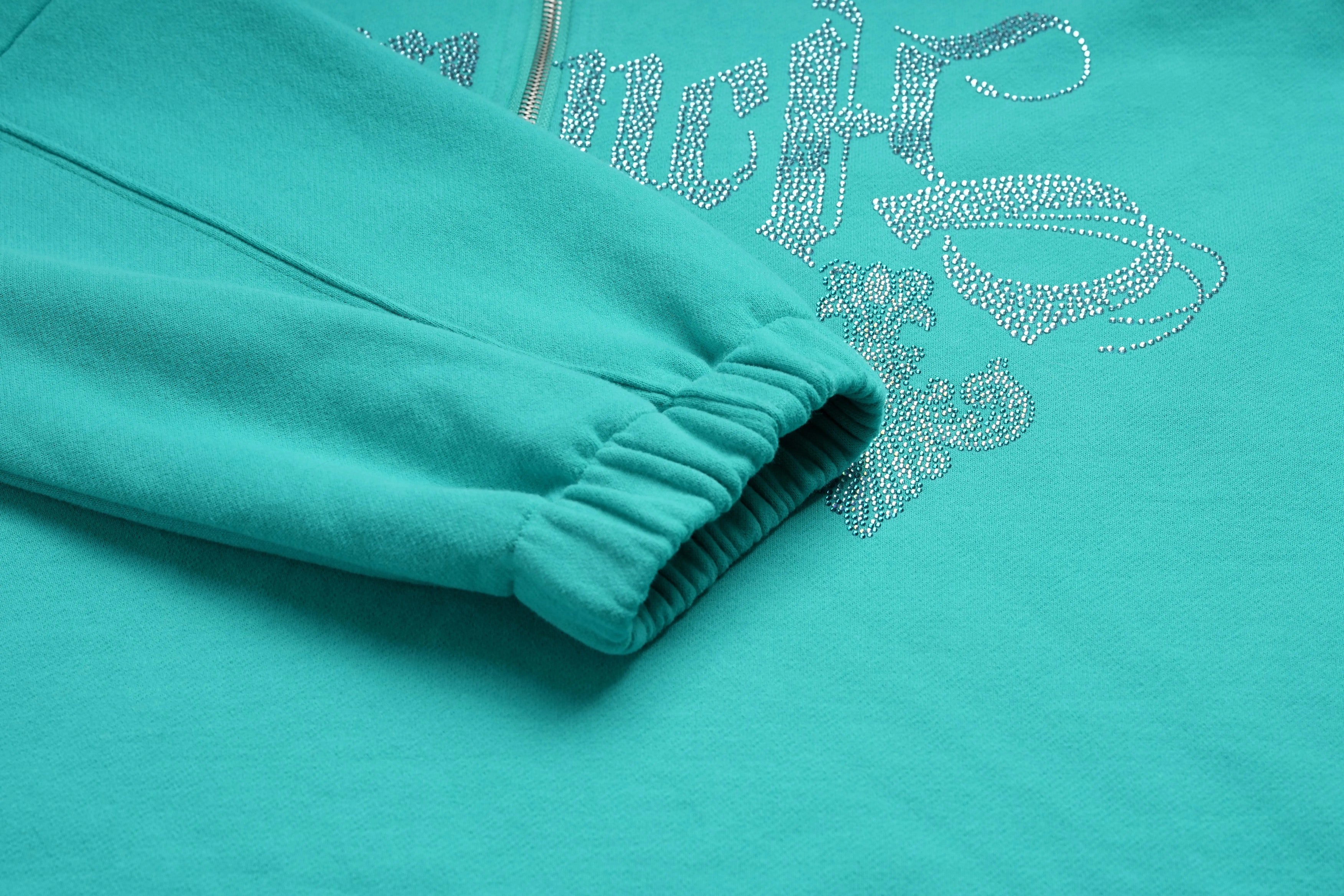 Teal sweatshirt with decorative text and floral design on a teal background, TCH Rhinestone “Tchmuch” Logo & Wings Teal Zip Tracksuit Set