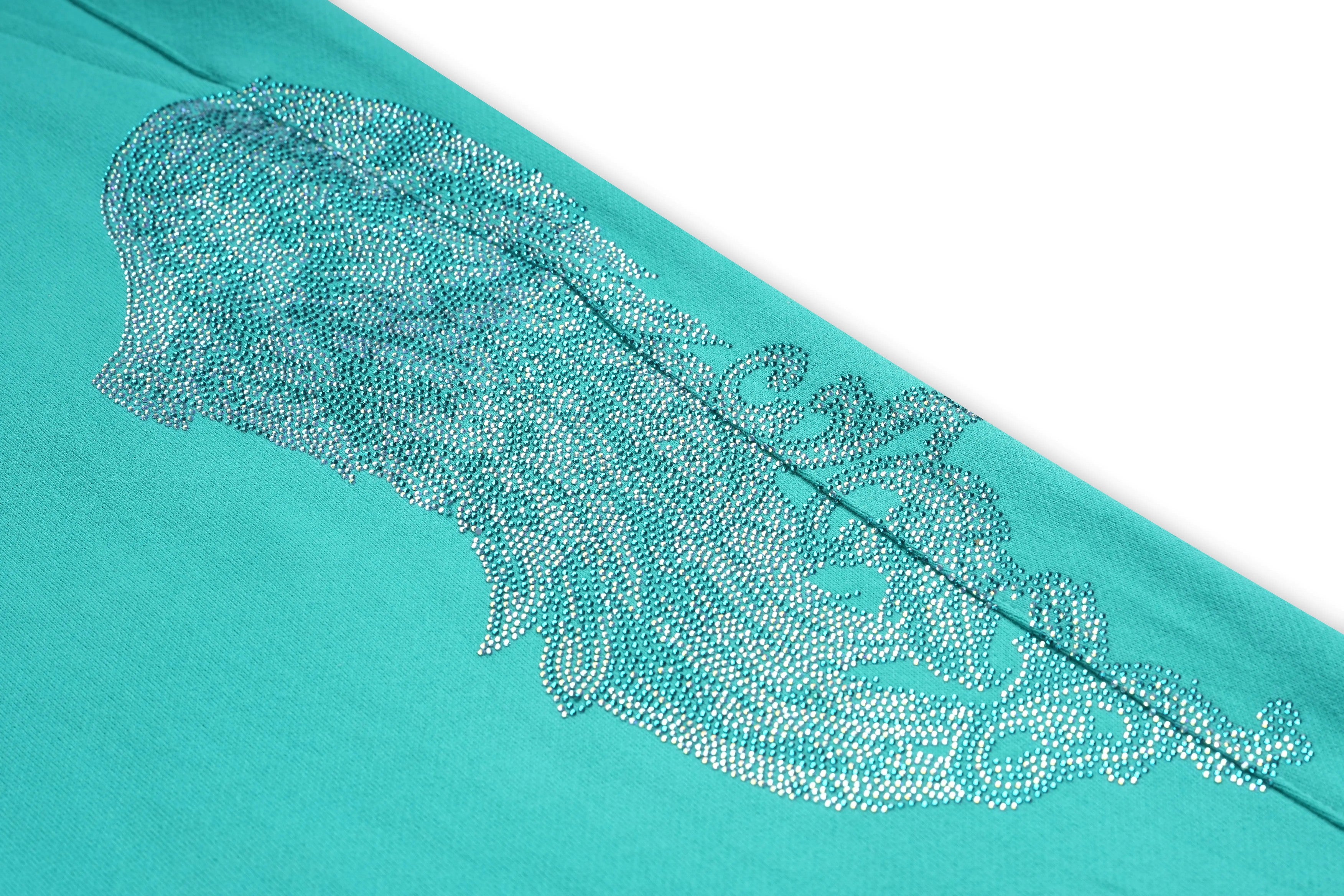 Teal fabric with a decorative silver pattern on a white background, TCH Rhinestone “Tchmuch” Logo & Wings Teal Zip Tracksuit Set