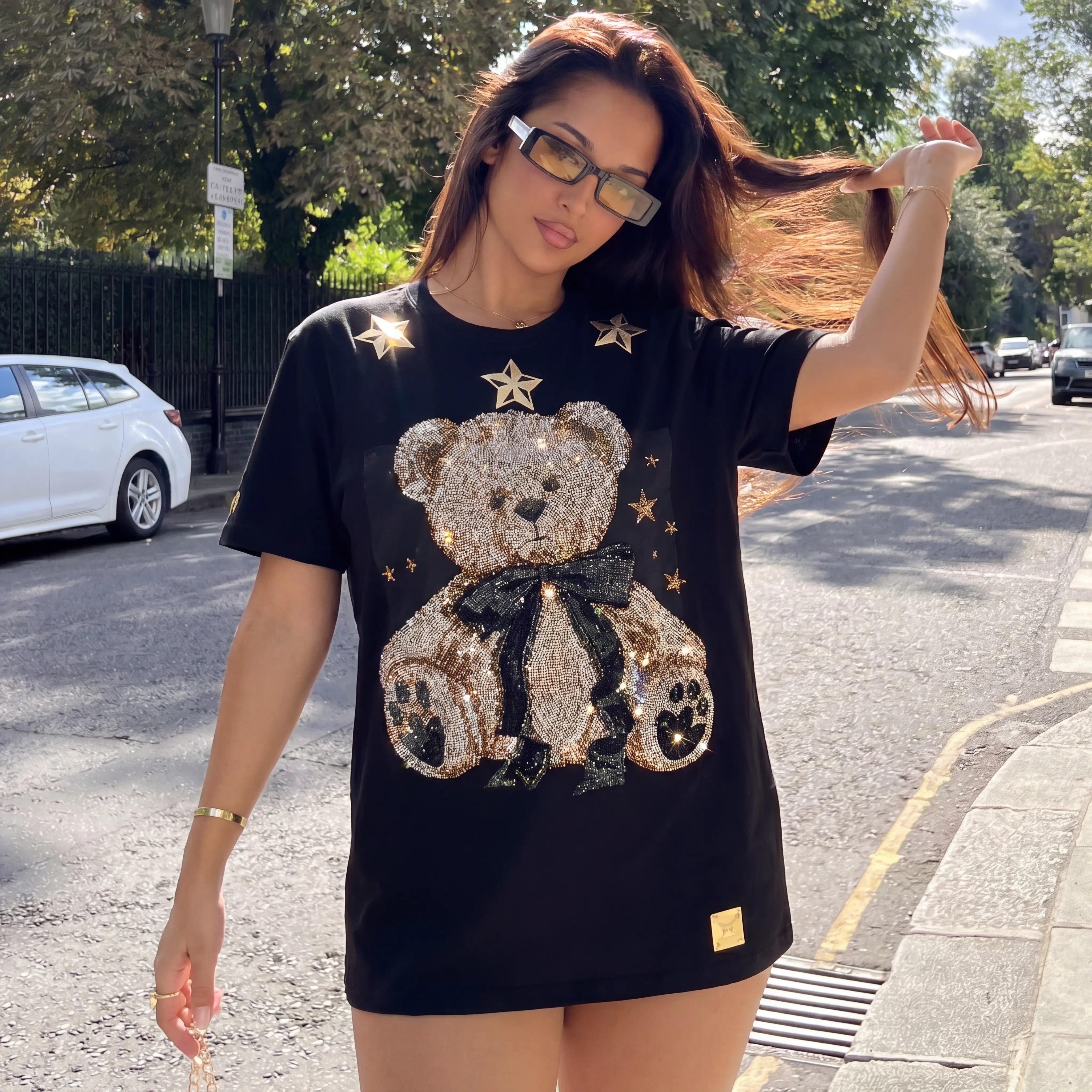 Woman wearing a black t-shirt with a teddy bear design on a street. TCH Rhinestone Teddy Bear Black T-Shirt