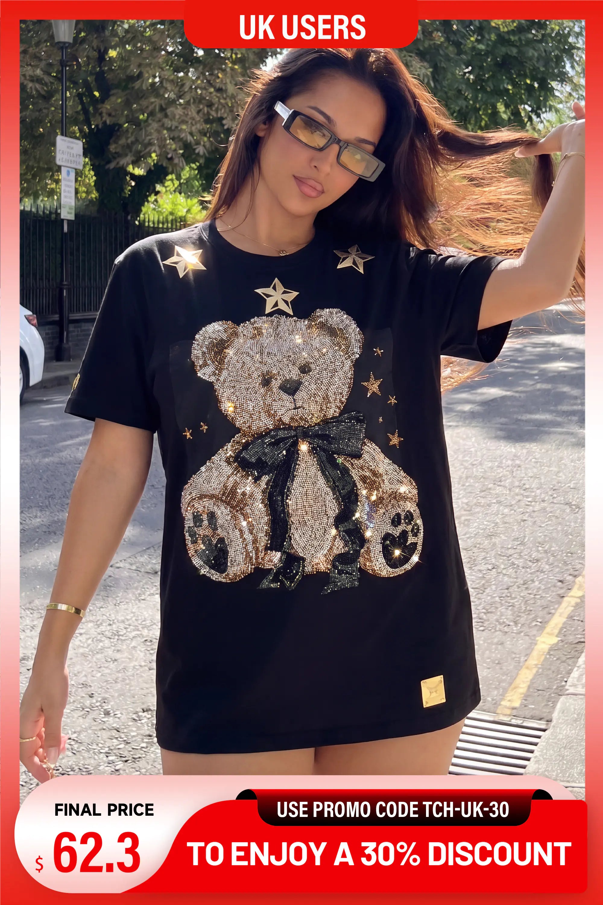 A woman outdoors wearing a black oversized T-shirt with a large teddy bear graphic made of gold and silver sequins, surrounded by small gold star sequins. The image has promotional overlays including 'UK USERS' at the top and a discount banner at the bottom. TCH Rhinestone Teddy Bear Black T-Shirt