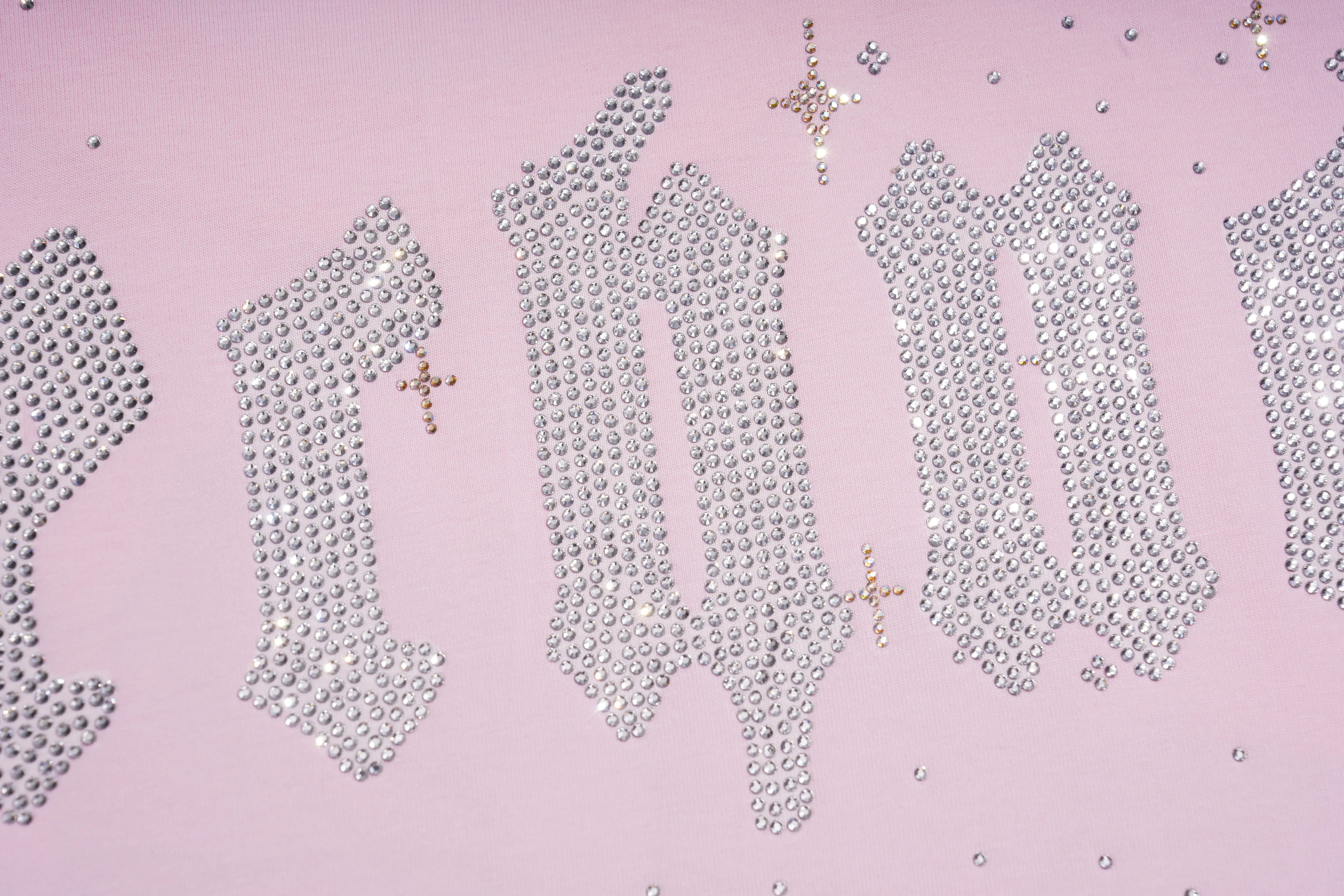 Silver rhinestone lettering spelling 'BROKEN' with small gold star embellishments on a light pink background. TCH Rhinestone Teddy Bear Bow Pink Graphic T-Shirt
