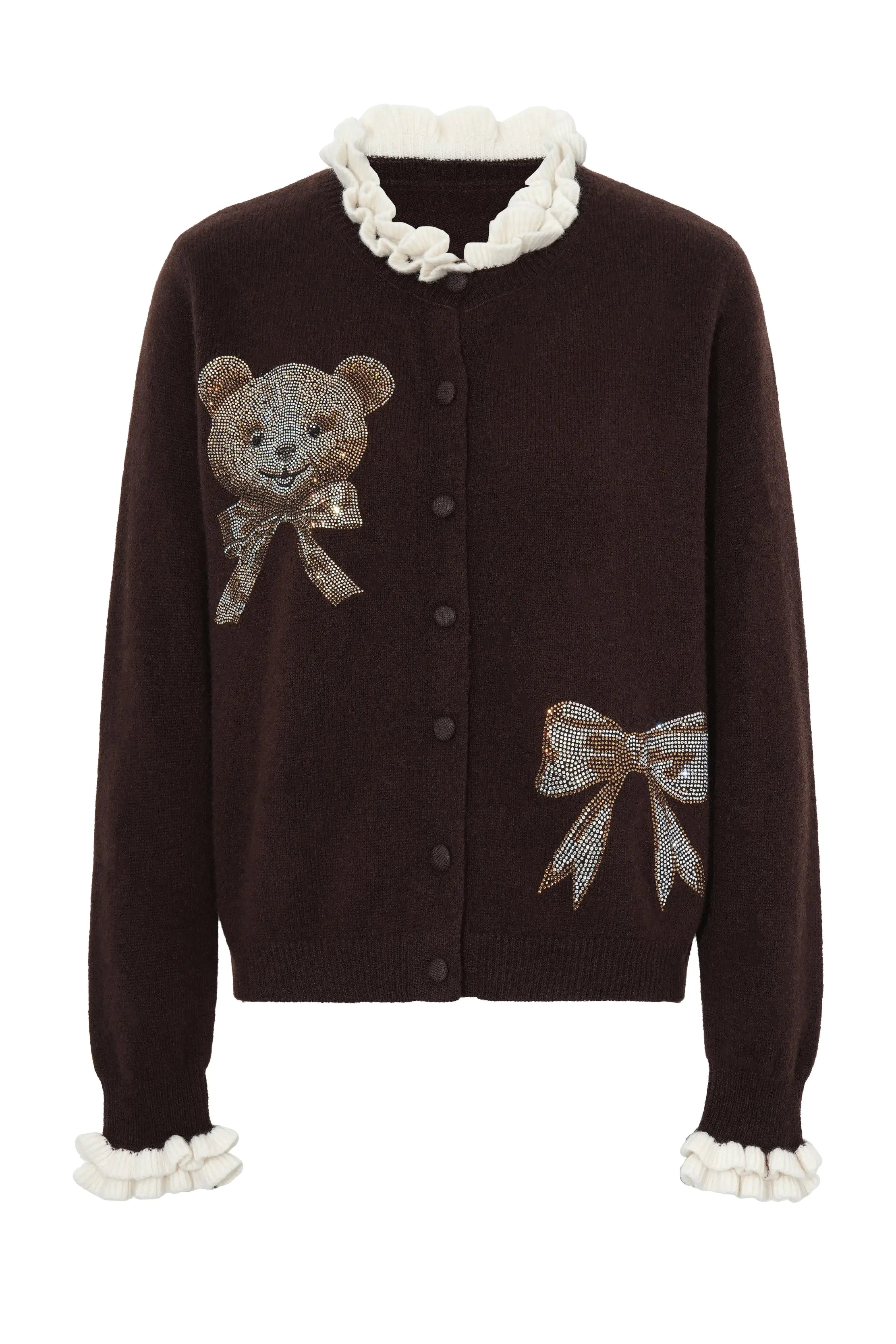 A dark brown knit cardigan sweater featuring a teddy bear face and bow embellishment on the left chest, a sequined bow on the lower right front, and white ruffled trim at the collar and cuffs, shown against a plain white background. TCH Rhinestone Teddy Bear Bow Ruffle Knit Cardigan