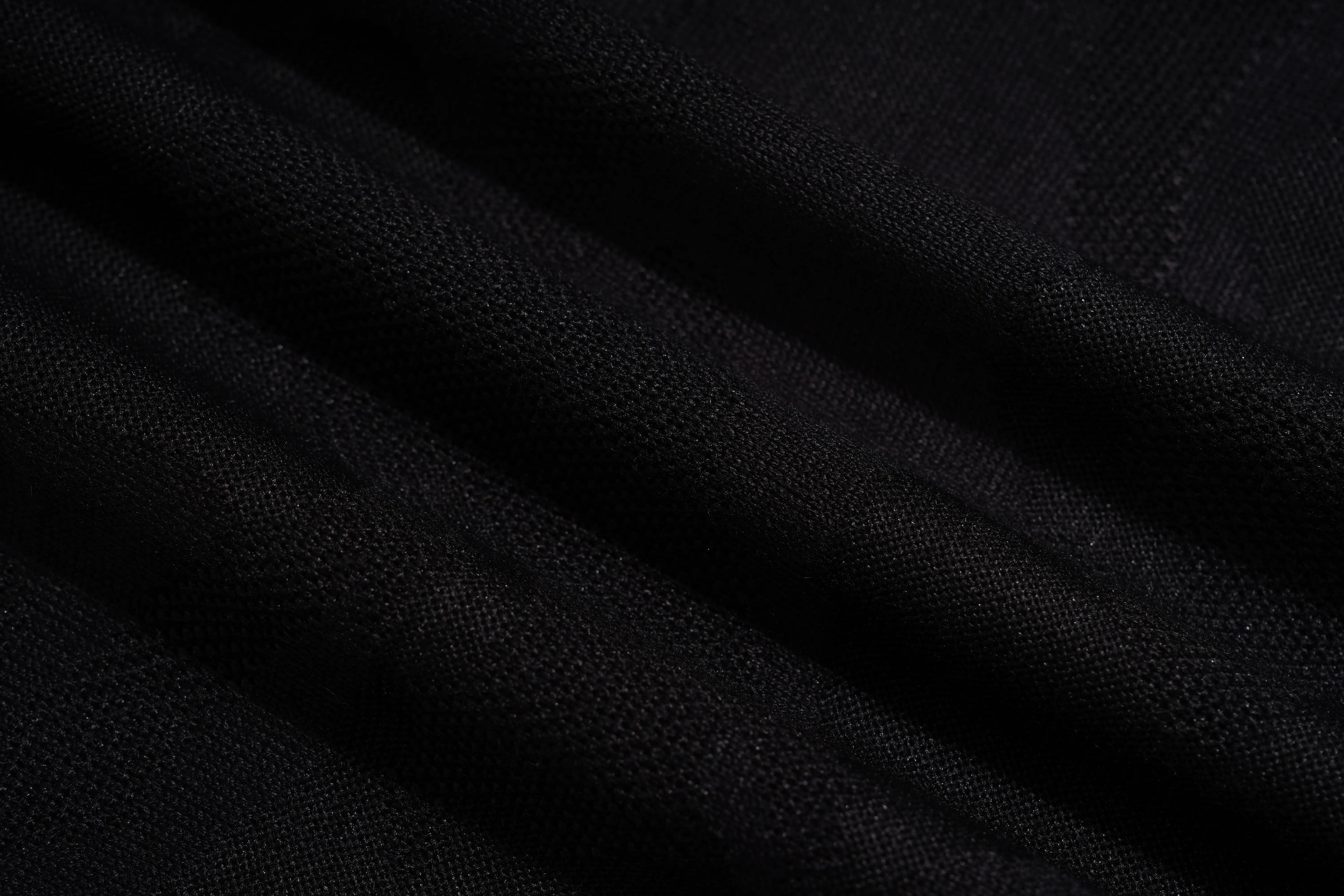A close-up of draped black fabric with a fine woven texture, showing soft folds and shadows. TCH Rhinestone Teddy Bear Pearl Chain Graphic Sweatshirt