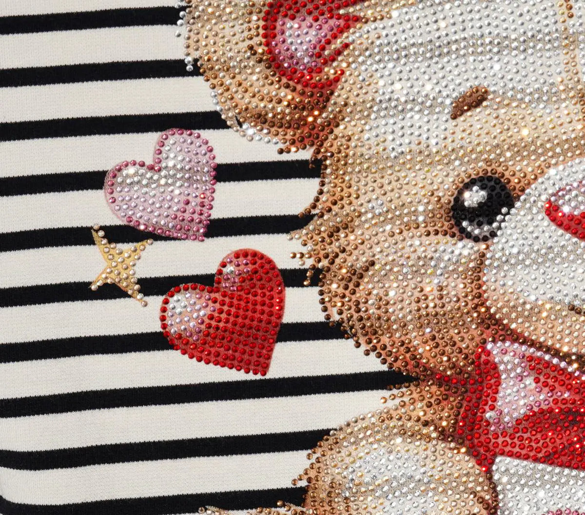 Close-up of a sequined teddy bear graphic on a black and white striped fabric background, featuring a beige bear with red accents and pink and red hearts. TCH Rhinestone Teddy Bear Striped Tie-Side T-Shirt
