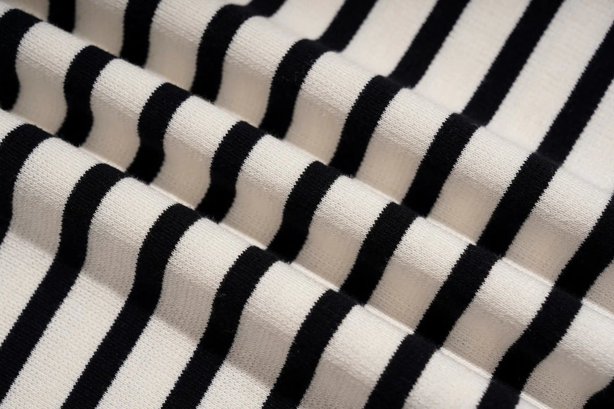 Close-up of a black and white striped knit fabric with a ribbed texture, shown in soft folds. TCH Rhinestone Teddy Bear Striped Tie-Side T-Shirt