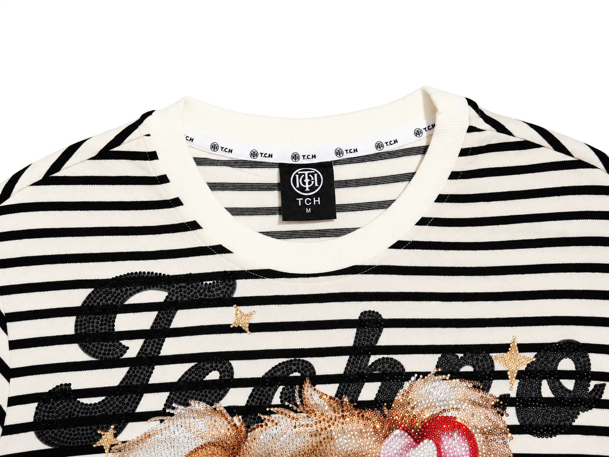 Close-up of a black and white striped TCH brand t-shirt featuring a large black sequined script across the chest and a gold and red sequined graphic at the bottom. TCH Rhinestone Teddy Bear Striped Tie-Side T-Shirt