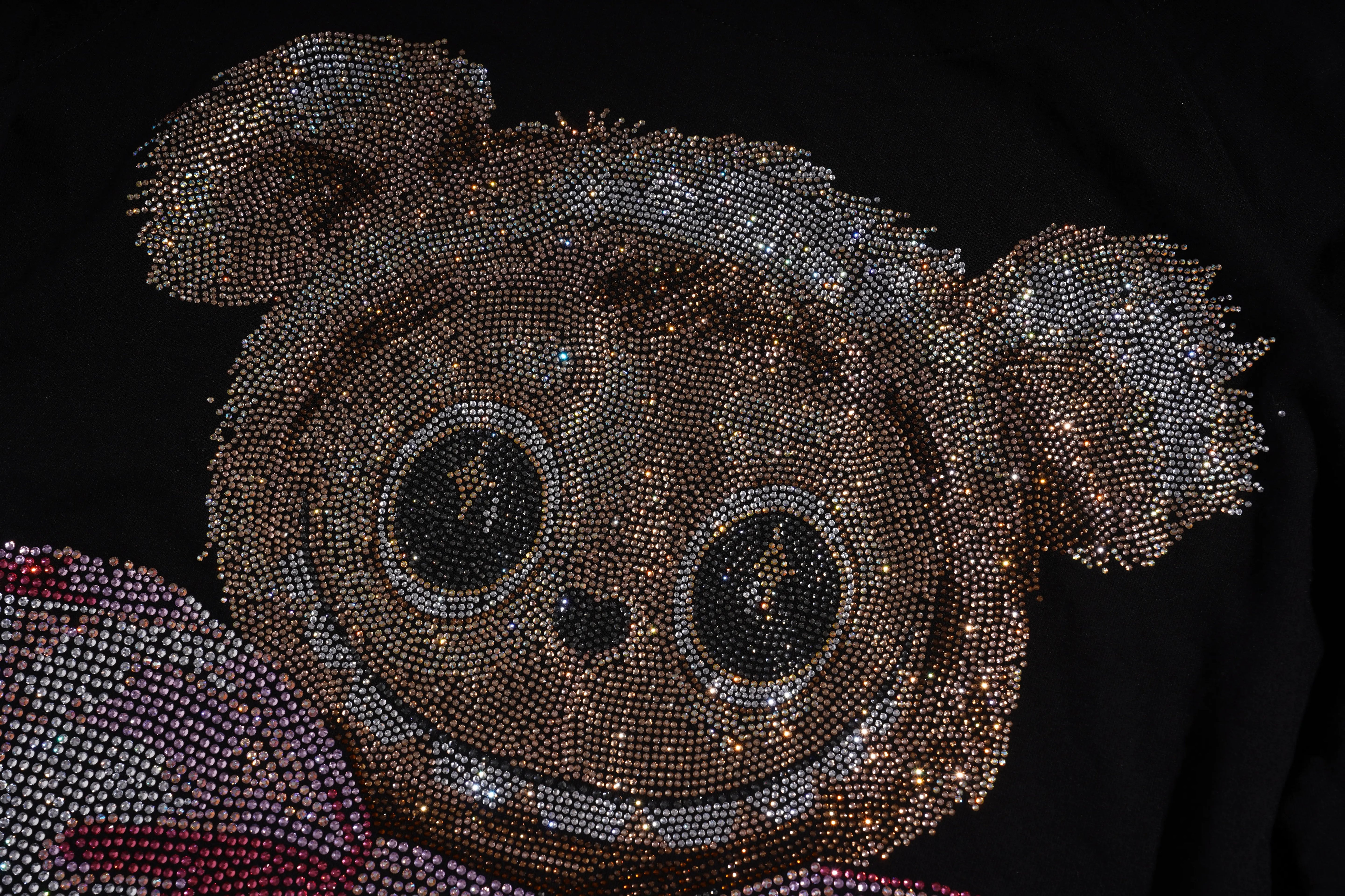 Decorative object resembling a face made of beads on a dark background, TCH Rhinestone Teddy Bear Sweatshirt